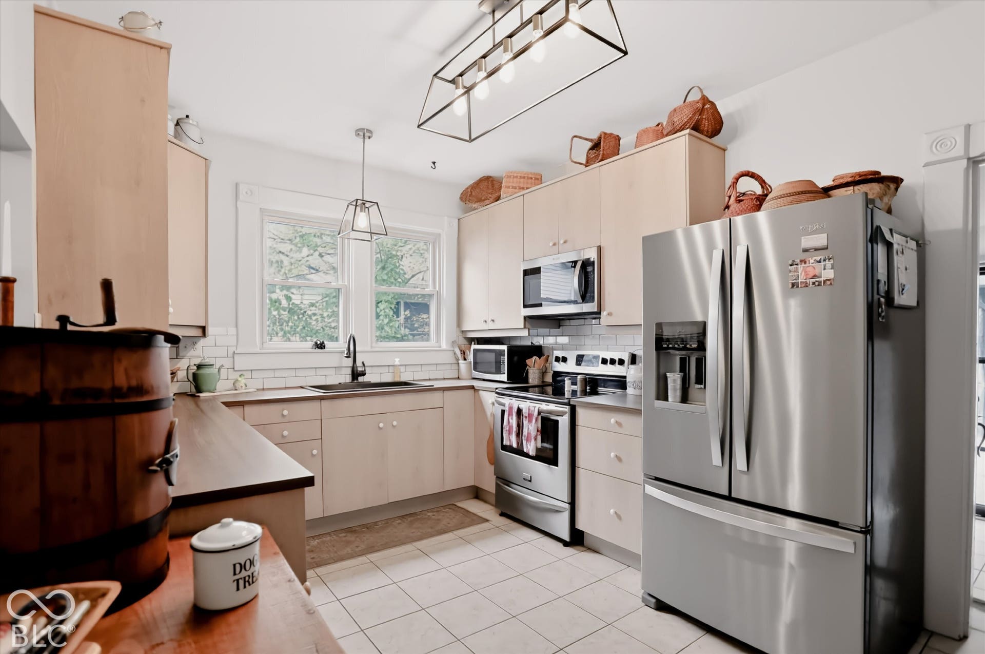 304 W 4th Street, Greenfield, IN 46140 Kitchen featuring light-finish cabinetry, stainless steel appliances, white subway tile backsplash, matte black faucet, and geometric pendant lighting