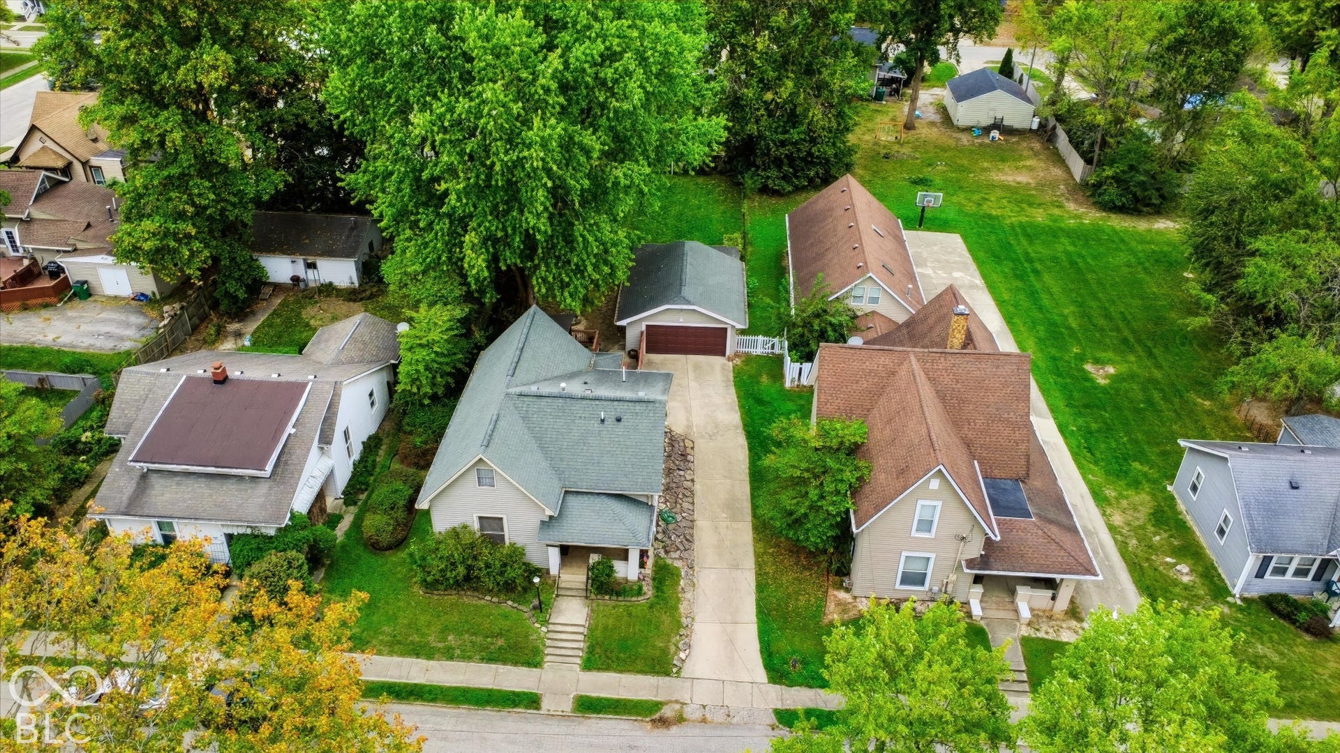 304 W 4th Street, Greenfield, IN 46140 Aerial perspective of a residential property featuring a pitched shingle roof, a detached garage, and a concrete driveway