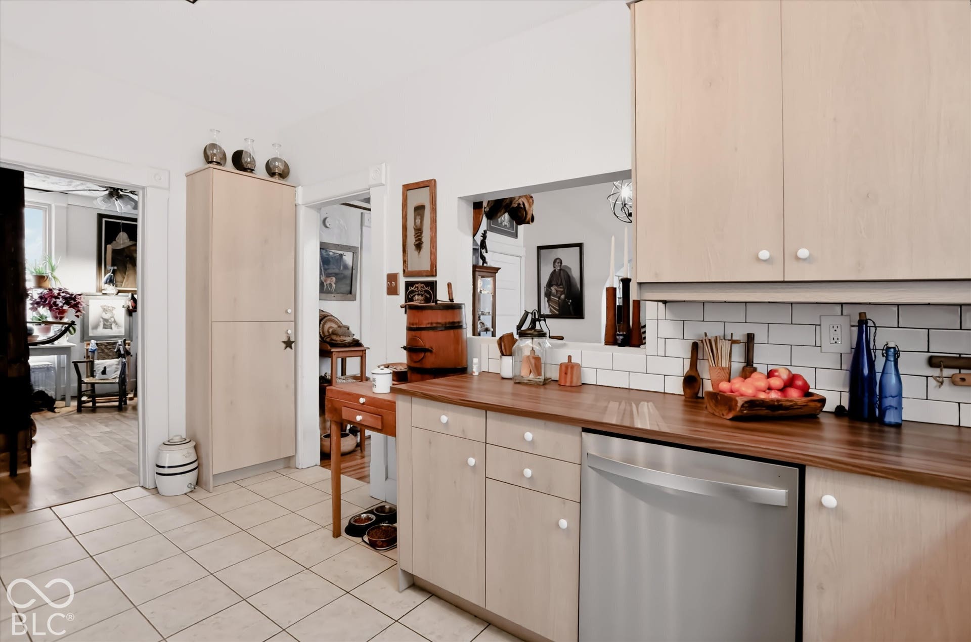 304 W 4th Street, Greenfield, IN 46140 Light wood-finish cabinetry featuring a pass-through window, butcher block countertop, white subway tile backsplash, and stainless steel dishwasher