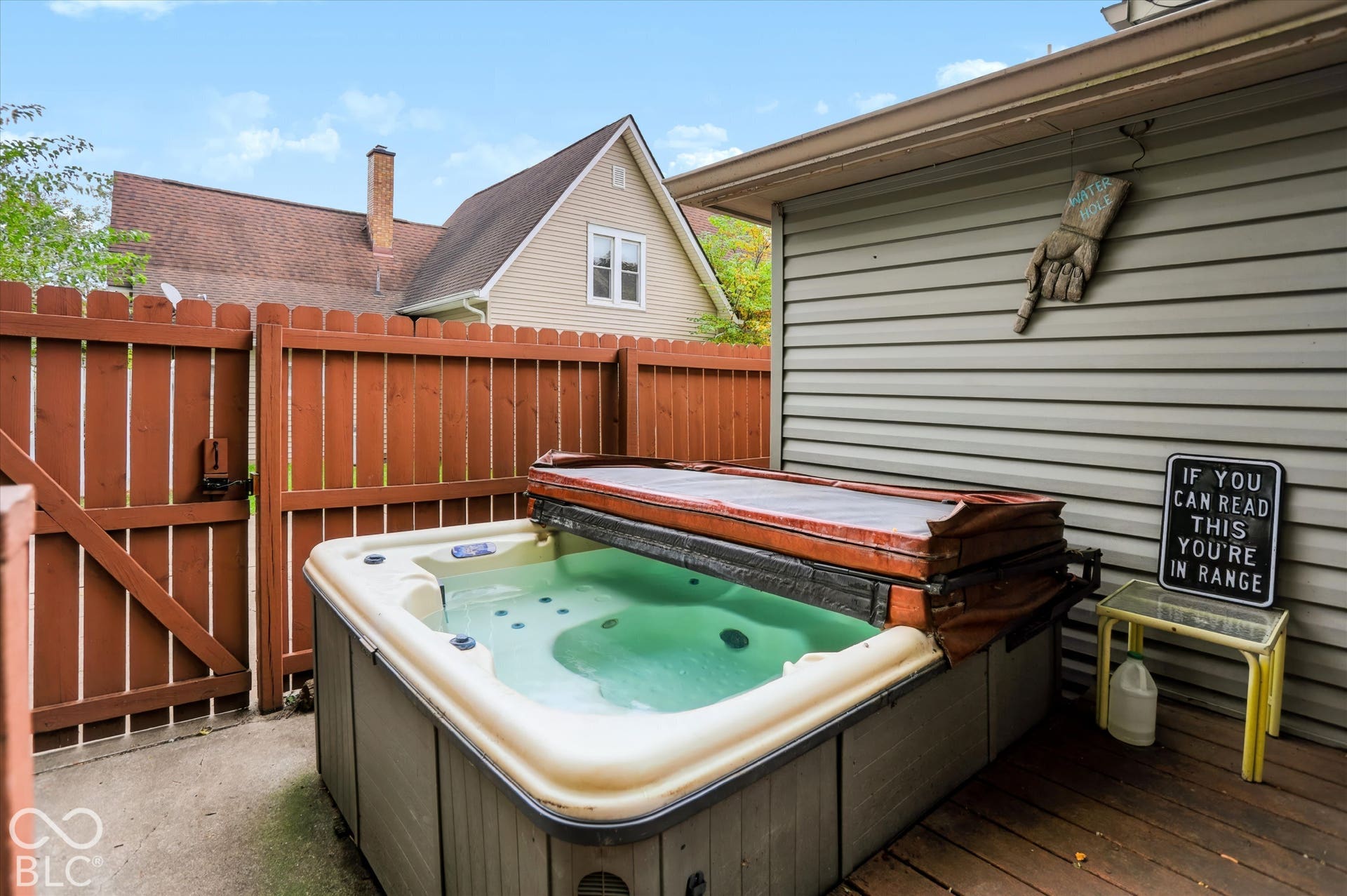 304 W 4th Street, Greenfield, IN 46140 Outdoor hot tub featuring a hard cover, wood-slat privacy fencing, and a concrete patio surface