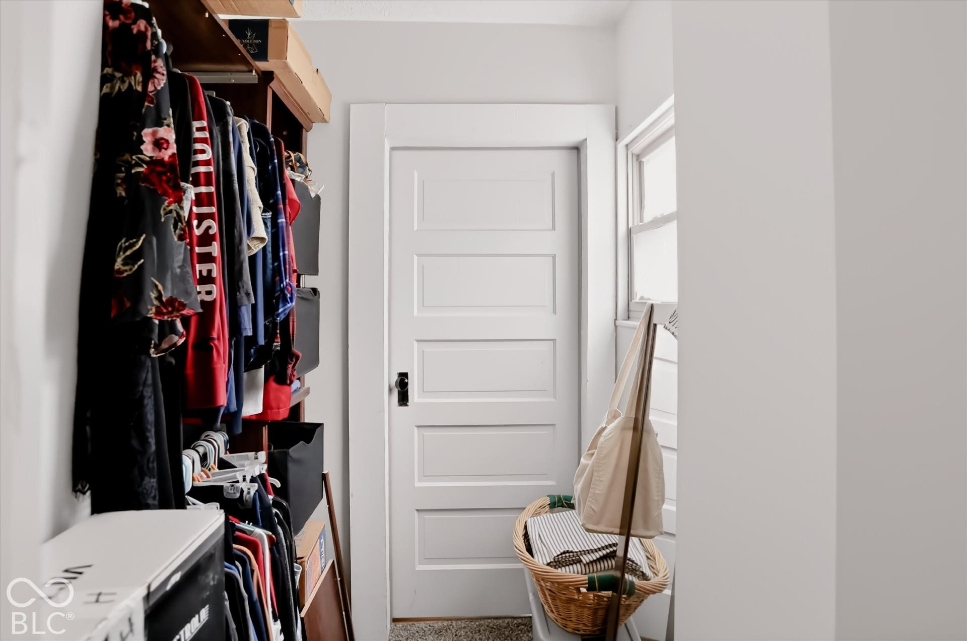 304 W 4th Street, Greenfield, IN 46140 Five-panel solid core door with matte black hardware, featuring a wooden built-in shelving unit and a window with white trim