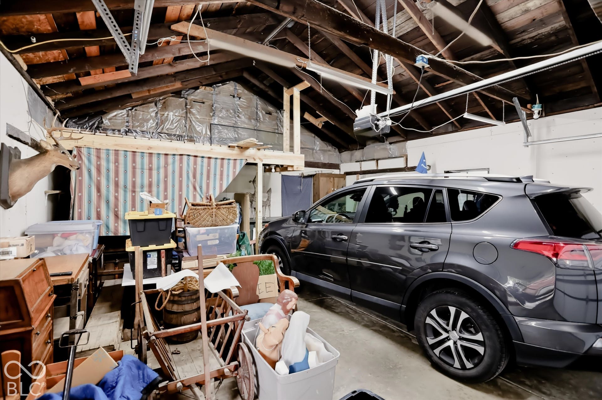 304 W 4th Street, Greenfield, IN 46140 Garage space featuring exposed timber rafters, a concrete floor, and overhead garage door opener