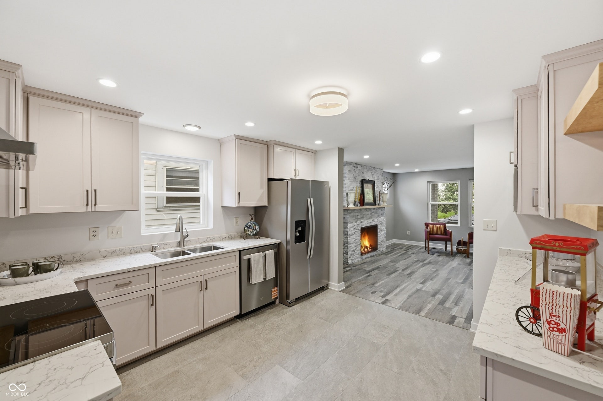 Contemporary kitchen featuring light cabinetry, quartz countertops, stainless steel appliances, and tile flooring