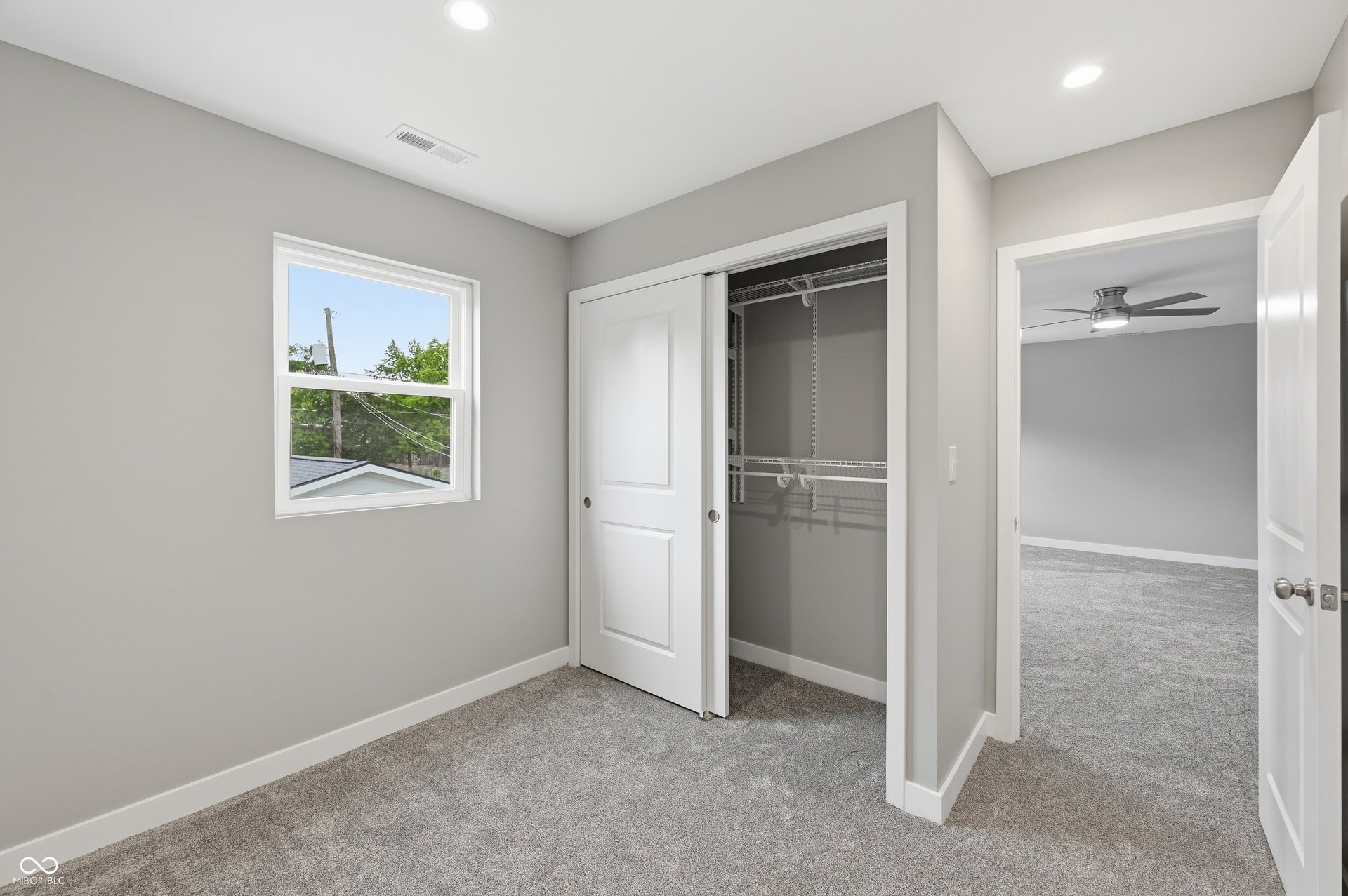 Interior room featuring plush gray carpeting, light gray wall paint, and white trim