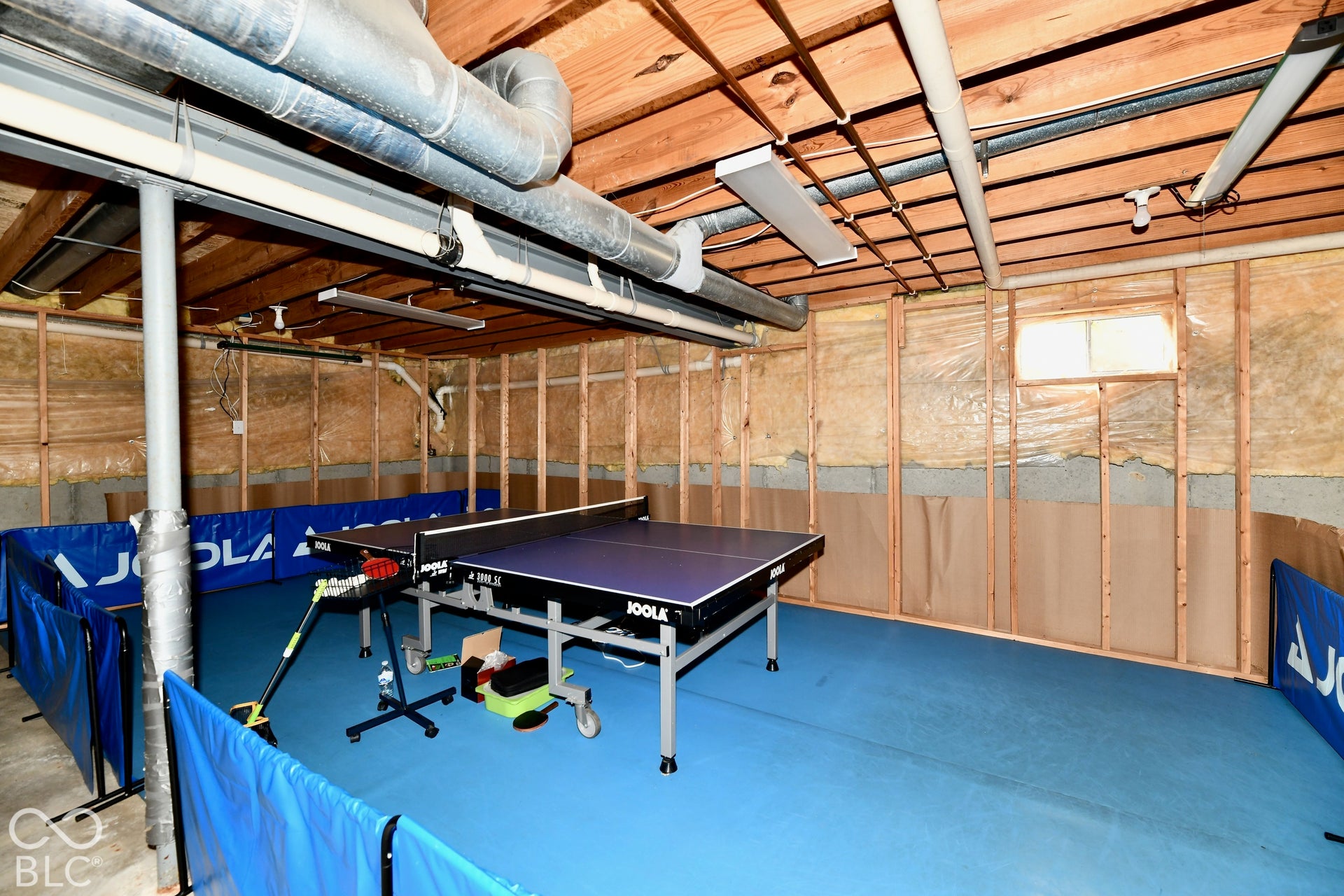 Unfinished utility space featuring exposed wood joist ceilings, metal ductwork, and stud-framed wall construction