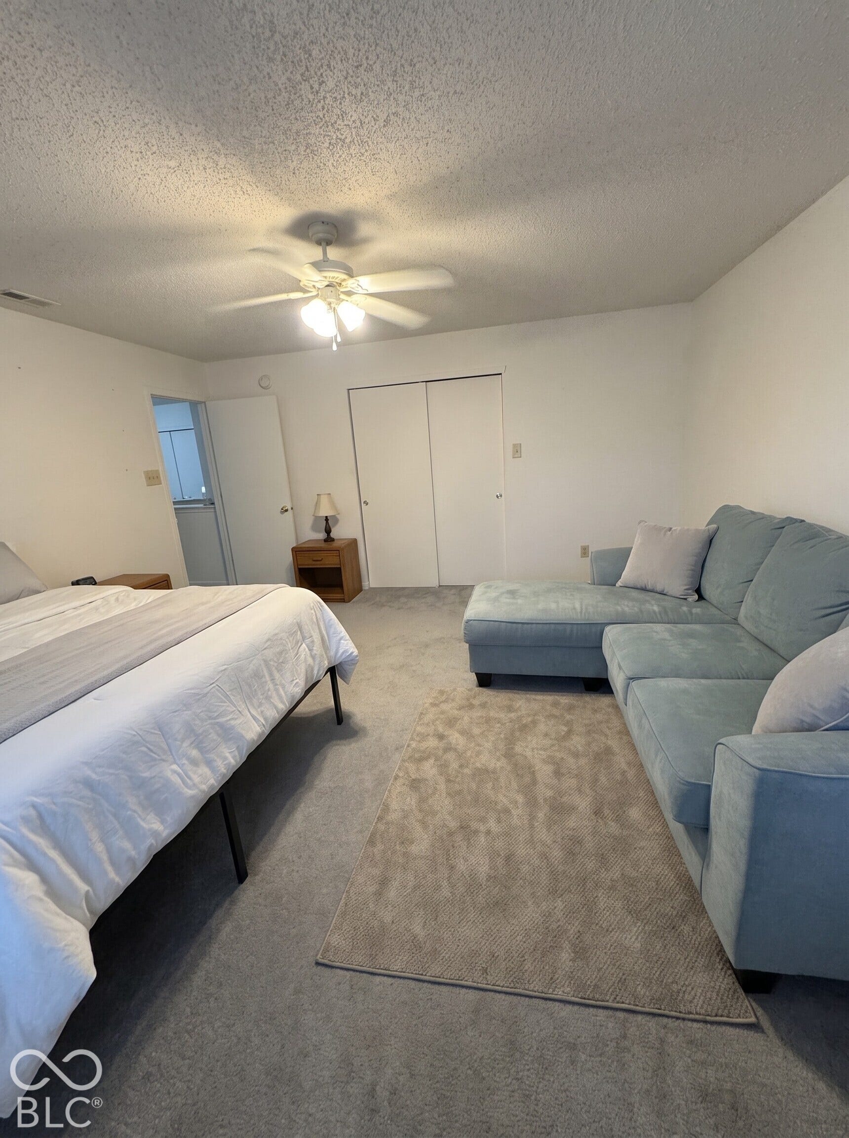Virtually Altered - Room featuring neutral carpeting, dual-door closet storage, and a ceiling fan with integrated lighting