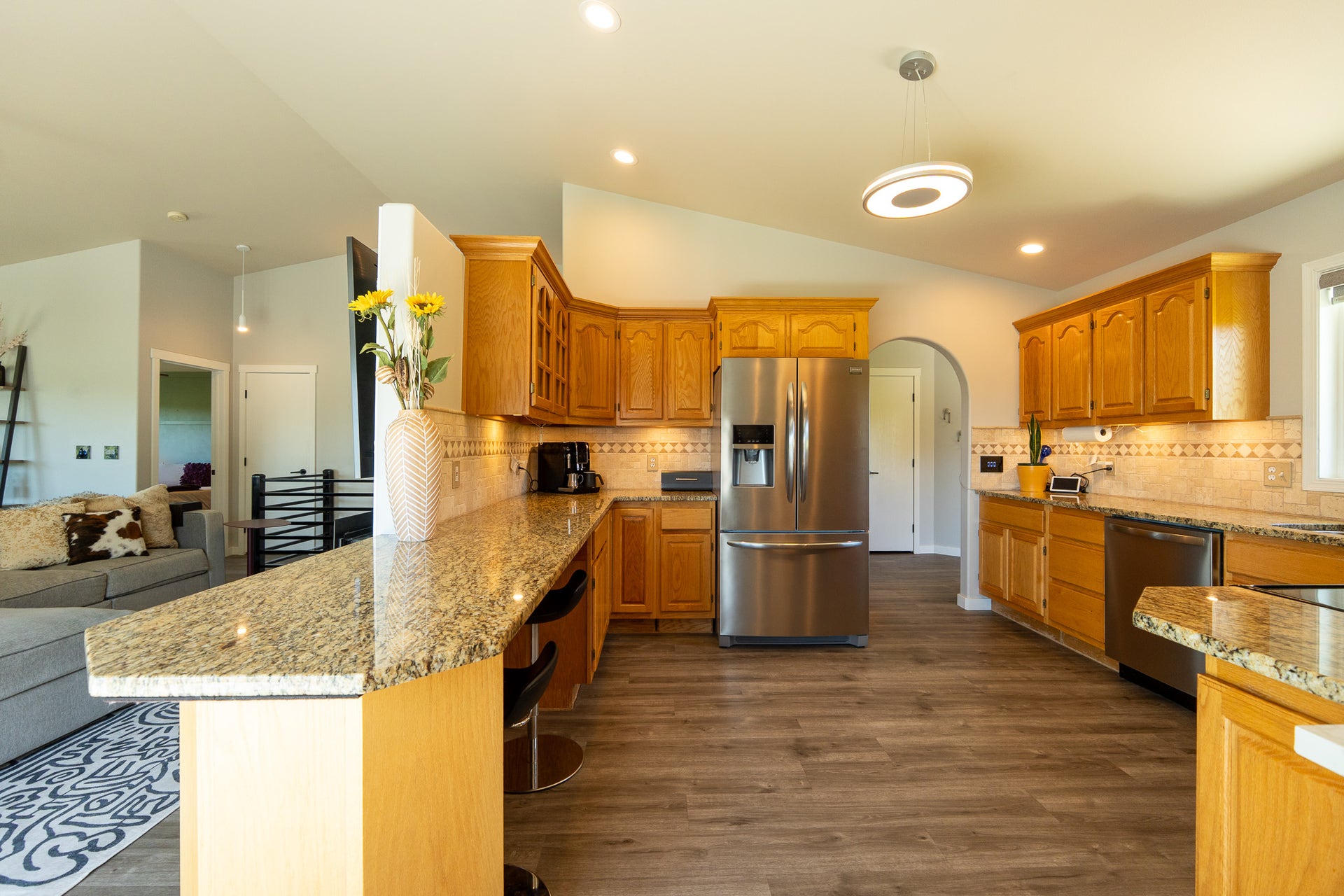 4134 Fox Ridge Drive, Helena, MT 59602 Kitchen with stainless steel appliances, lofted ceiling, a peninsula, glass insert cabinets, and dark wood-type flooring