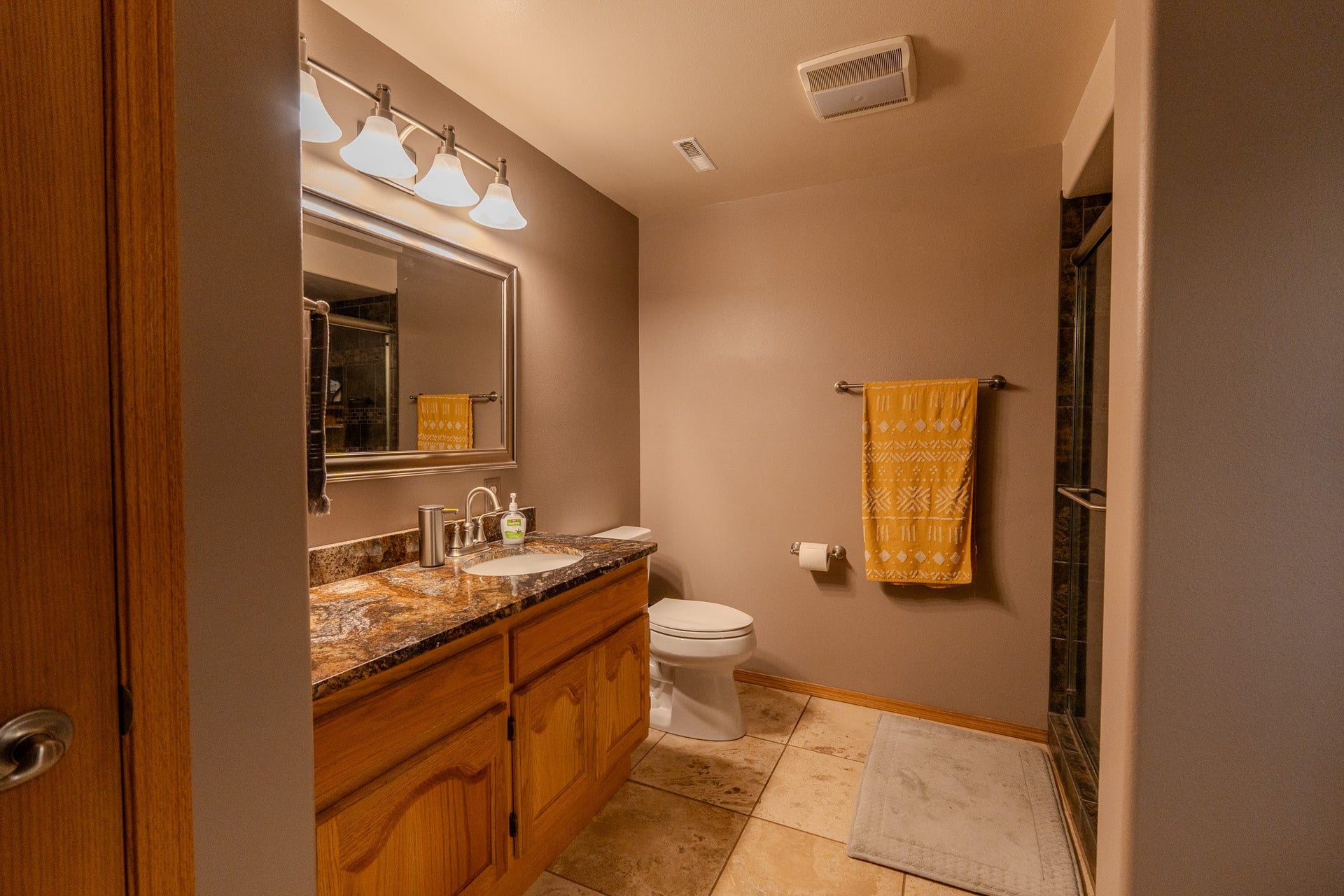 4134 Fox Ridge Drive, Helena, MT 59602 Bathroom featuring a shower with shower door, vanity, toilet, tile patterned flooring, and baseboards