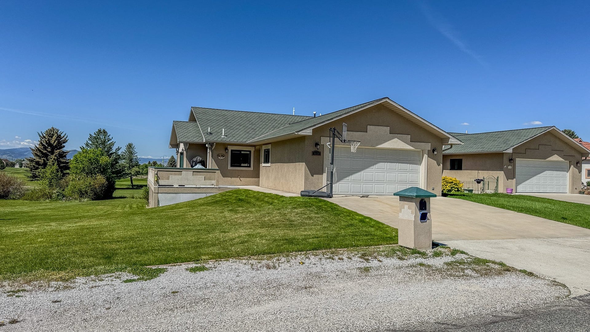 4134 Fox Ridge Drive, Helena, MT 59602 Ranch-style home with stucco siding, a front yard, an attached garage, and driveway