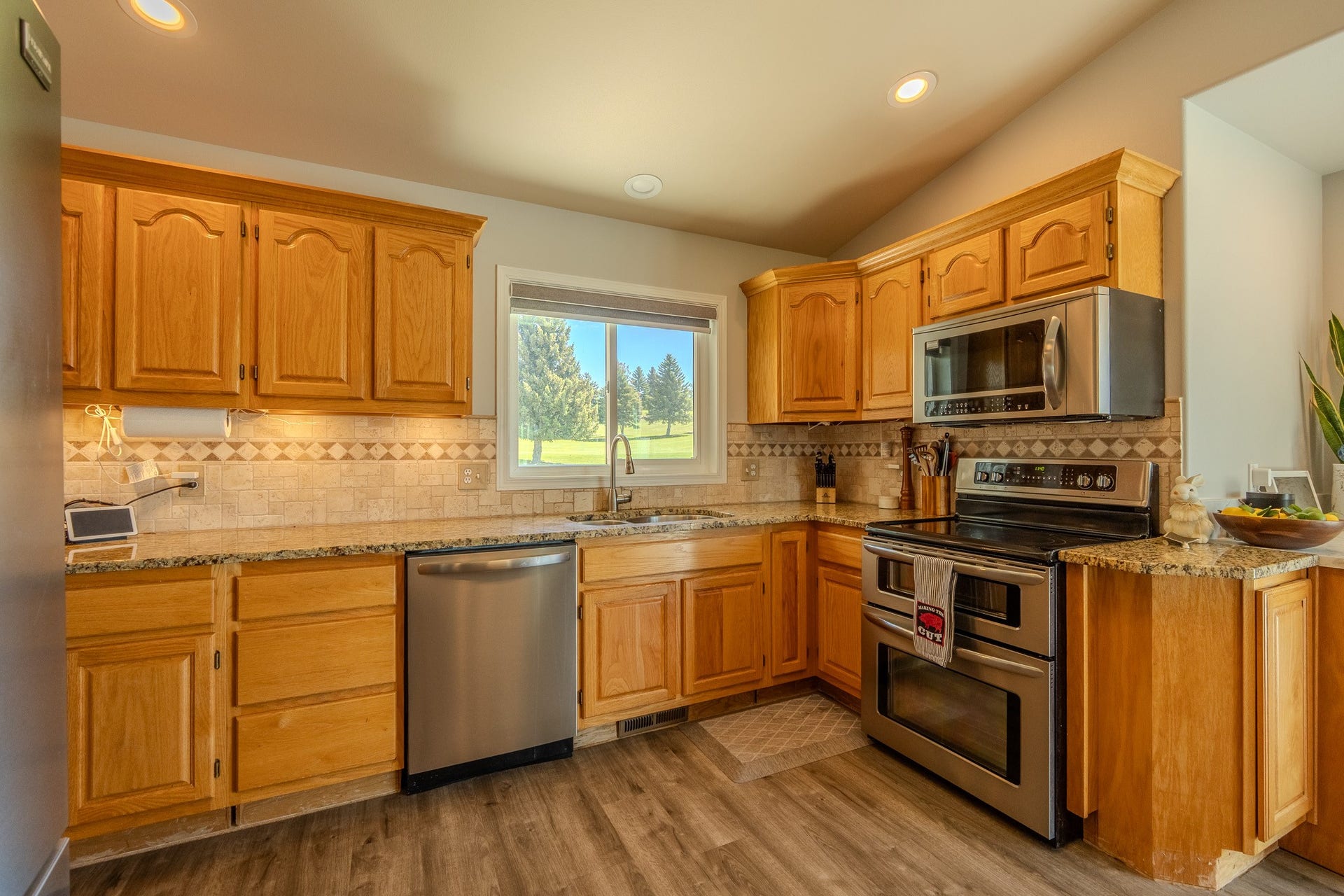 4134 Fox Ridge Drive, Helena, MT 59602 Kitchen featuring appliances with stainless steel finishes, a sink, light stone countertops, backsplash, and lofted ceiling