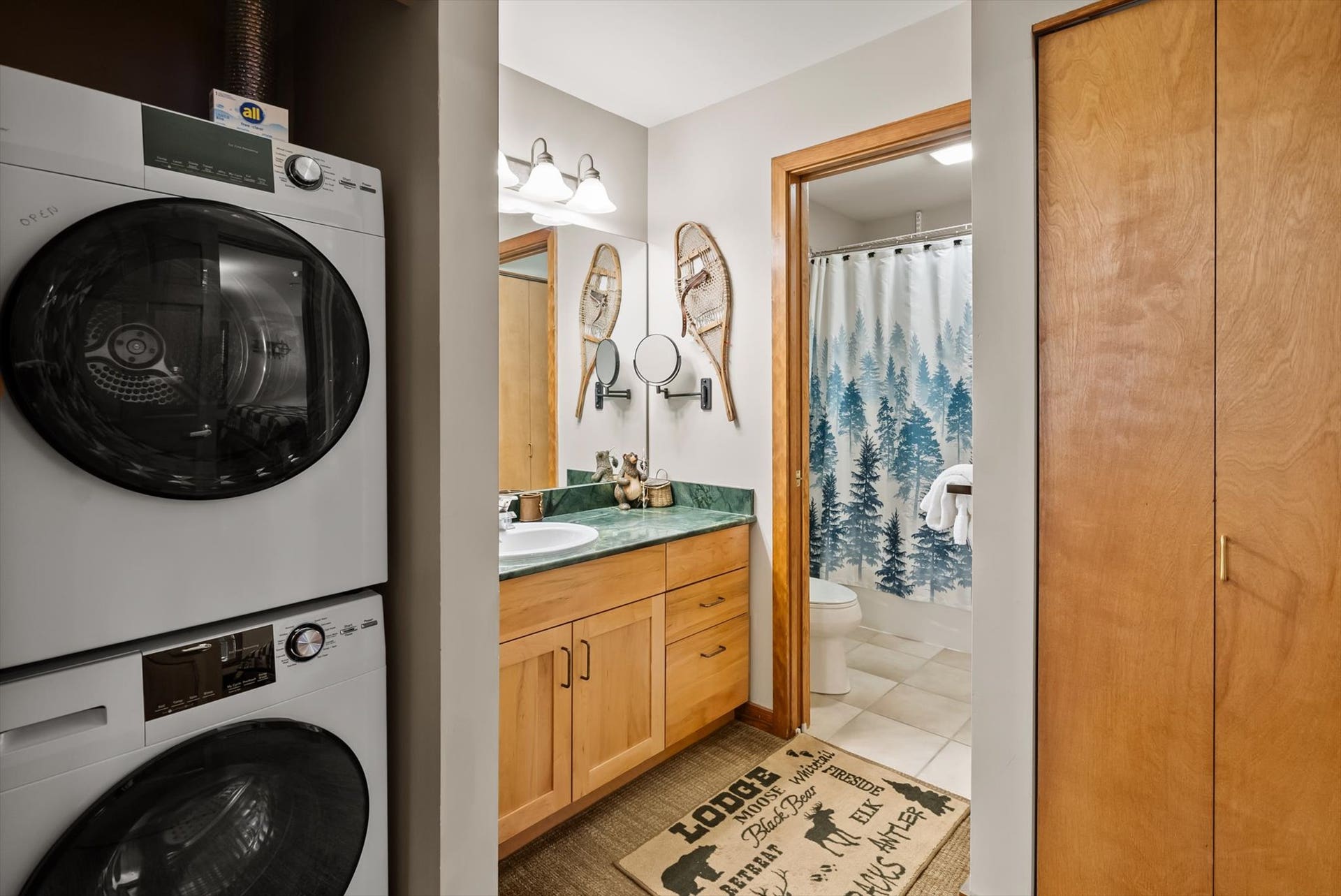 Stacked washer and dryer adjacent to full bathroom