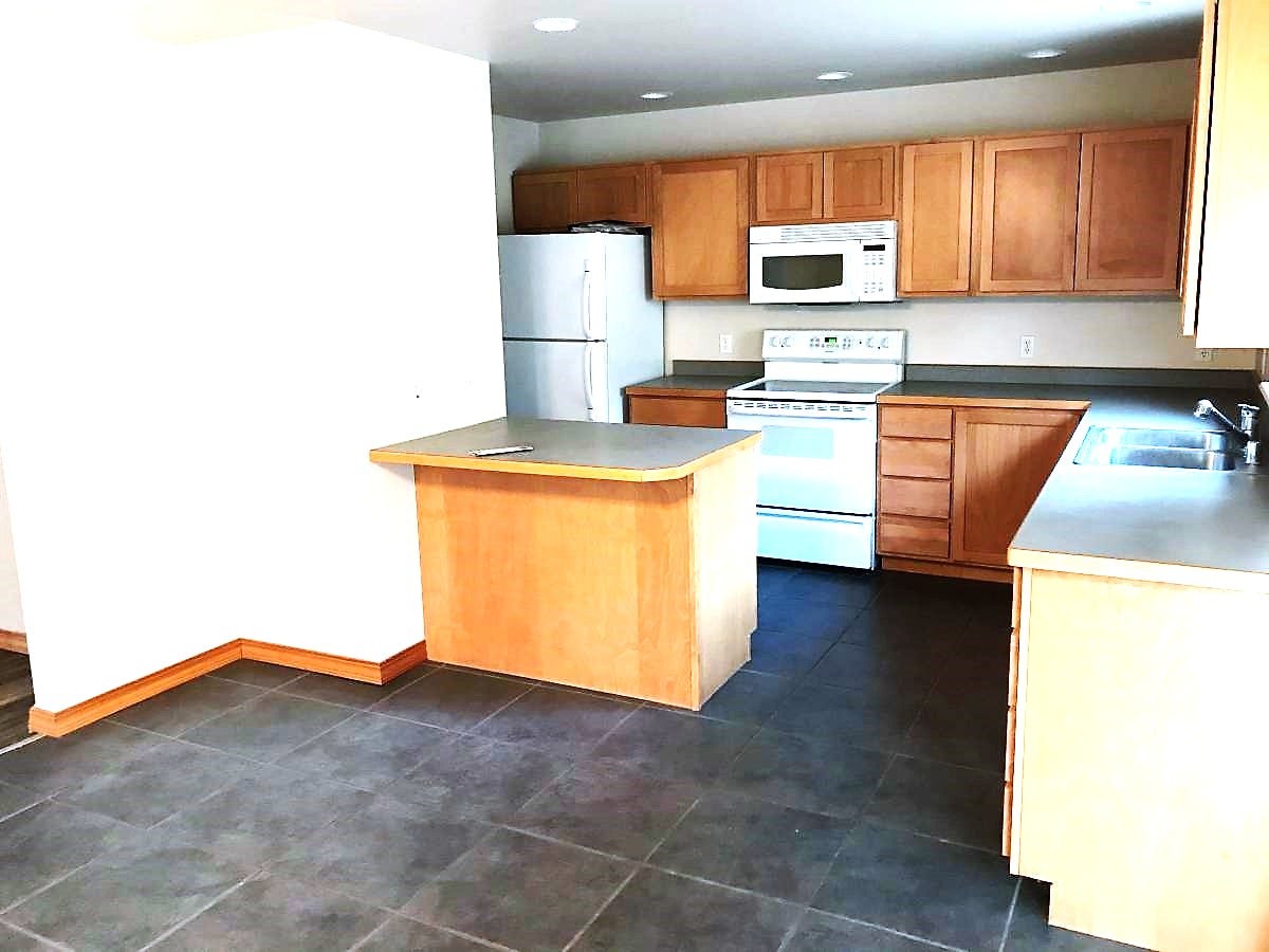 114 Sunrise Terrace, #114, Bigfork, MT 59911 Kitchen featuring a sink, baseboards, a peninsula, recessed lighting, and white appliances