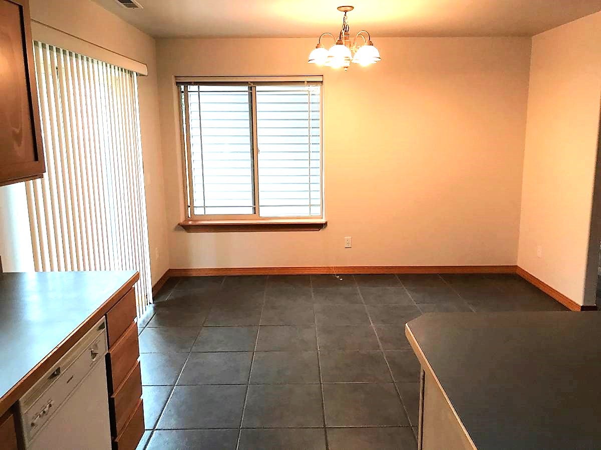 114 Sunrise Terrace, #114, Bigfork, MT 59911 Unfurnished dining area featuring baseboards, dark tile patterned floors, and a chandelier