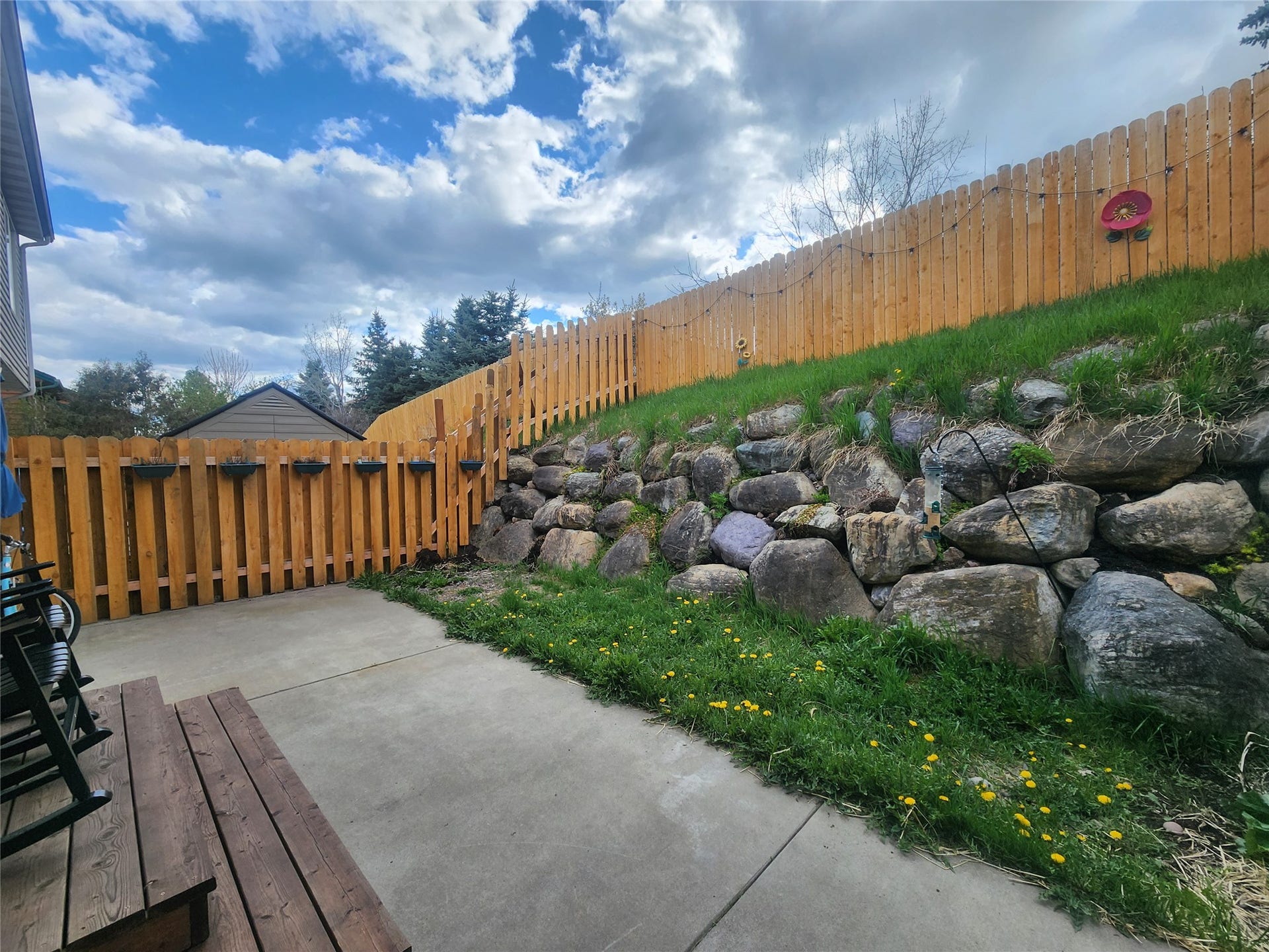 114 Sunrise Terrace, #114, Bigfork, MT 59911 Concrete patio with a rock retaining wall and wood picket fencing
