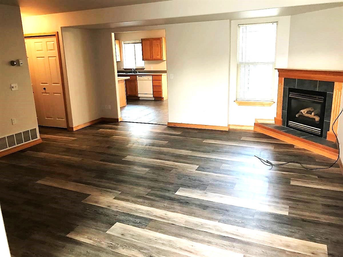 114 Sunrise Terrace, #114, Bigfork, MT 59911 Unfurnished living room featuring visible vents, baseboards, dark wood-style flooring, and a fireplace