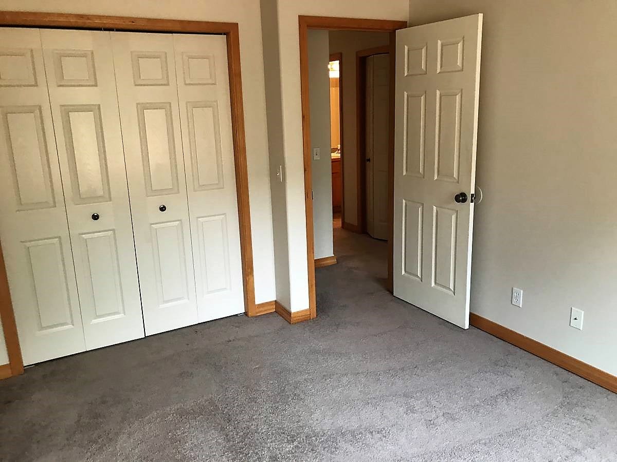 114 Sunrise Terrace, #114, Bigfork, MT 59911 Unfurnished bedroom featuring baseboards, carpet, and a closet