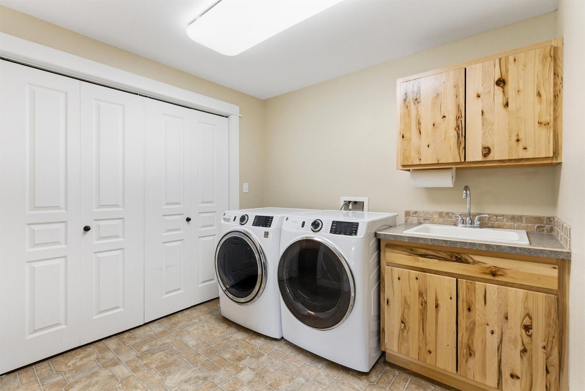 45 Roybals Way, Kalispell, MT 59901 Laundry area featuring cabinet space, separate washer and dryer, and stone finish floors