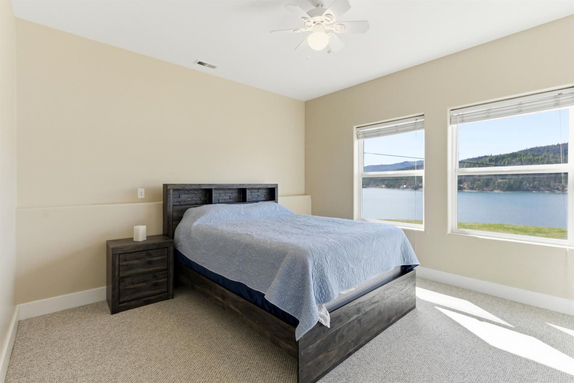 45 Roybals Way, Kalispell, MT 59901 Bedroom with light colored carpet, a water view, and a ceiling fan