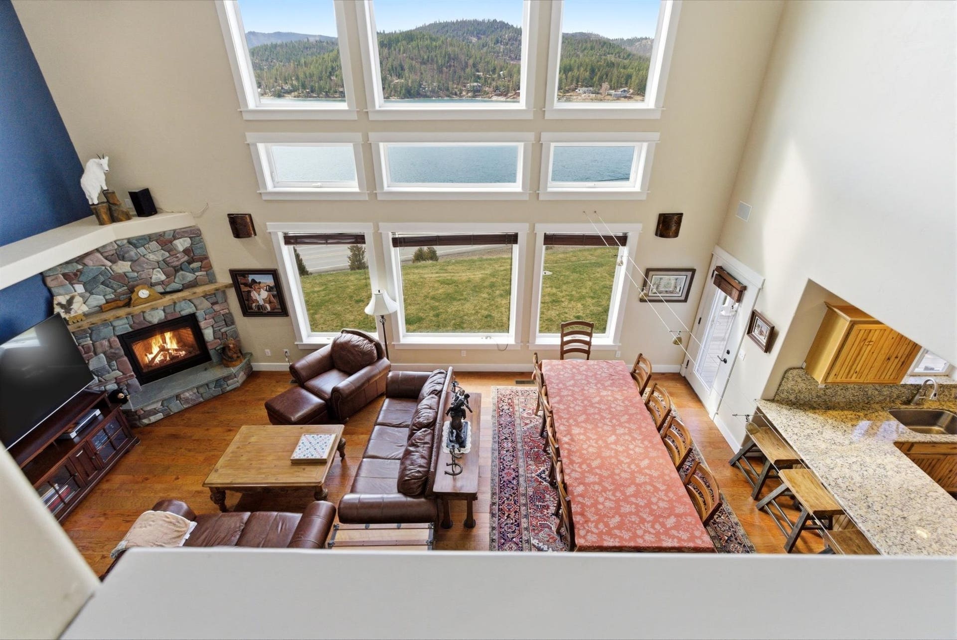 45 Roybals Way, Kalispell, MT 59901 Living room featuring a high ceiling, a stone fireplace, and dark wood-style flooring