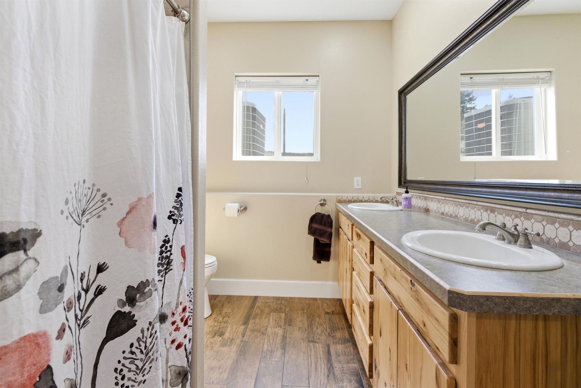 45 Roybals Way, Kalispell, MT 59901 Full bathroom featuring a shower with shower curtain, double vanity, and dark wood-type flooring