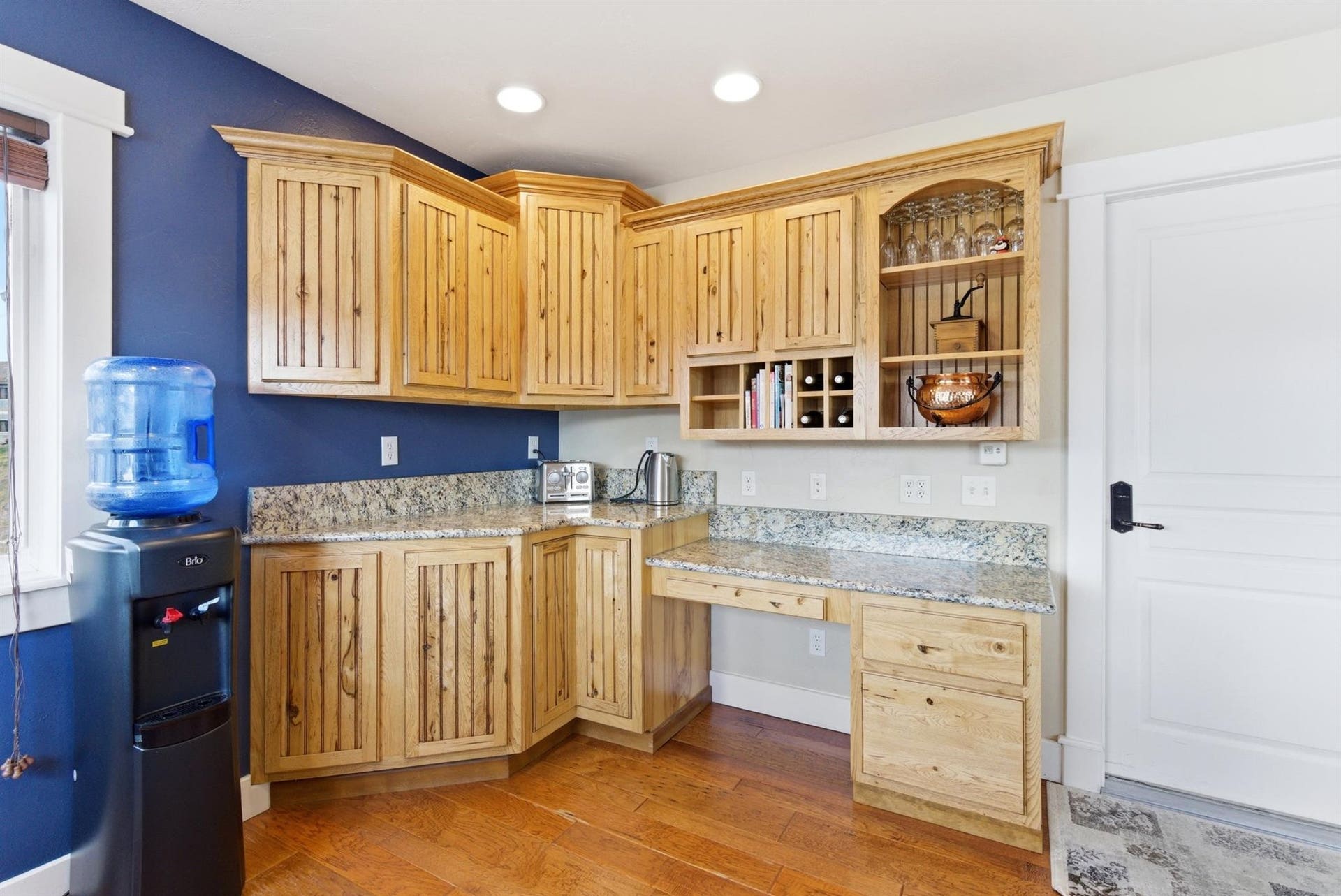 45 Roybals Way, Kalispell, MT 59901 Kitchen with light wood finish cabinets, light wood-style flooring, light stone counters, open shelves, and built in study area