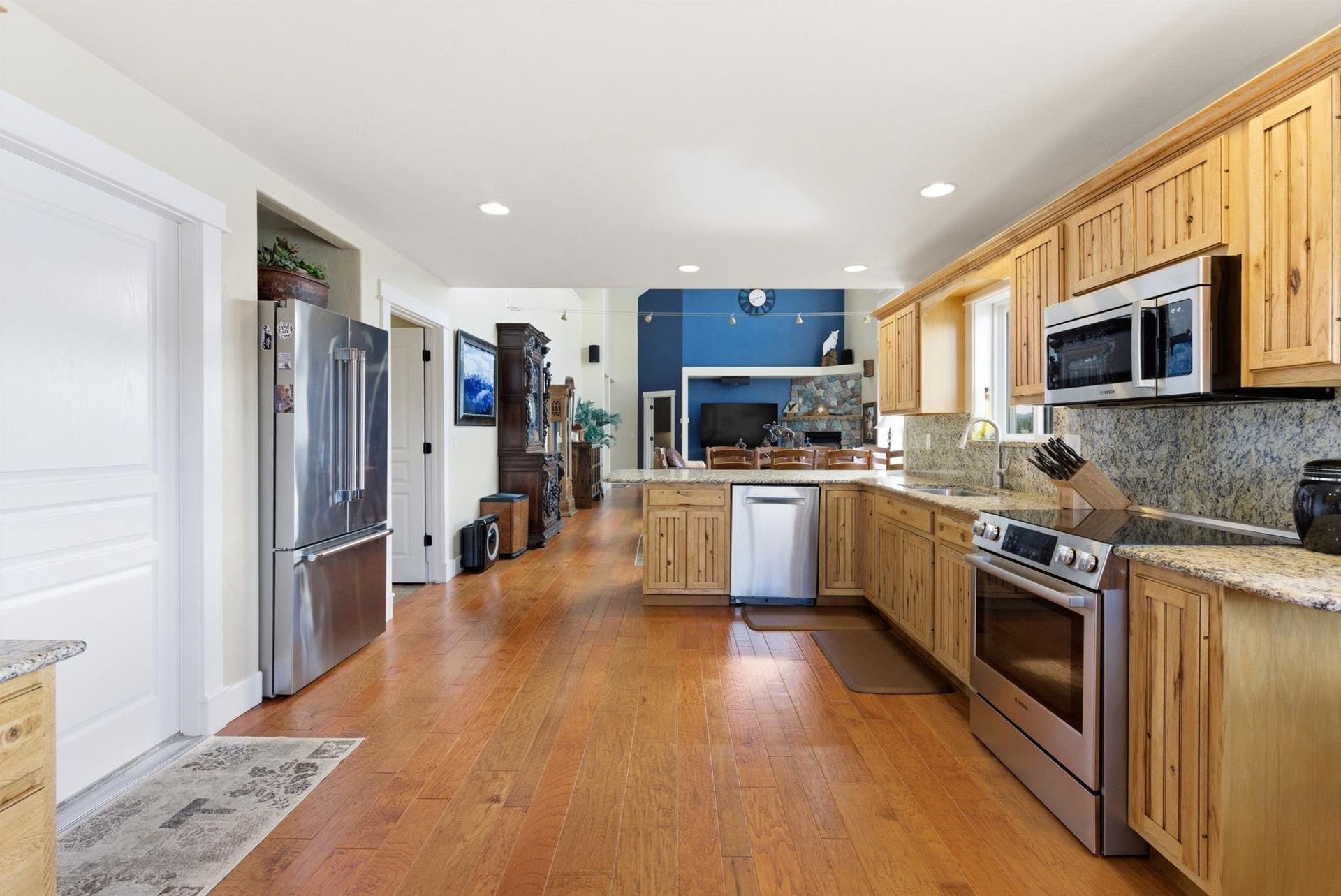 45 Roybals Way, Kalispell, MT 59901 Kitchen with stainless steel appliances, a peninsula, light wood-type flooring, tasteful backsplash, and light stone counters