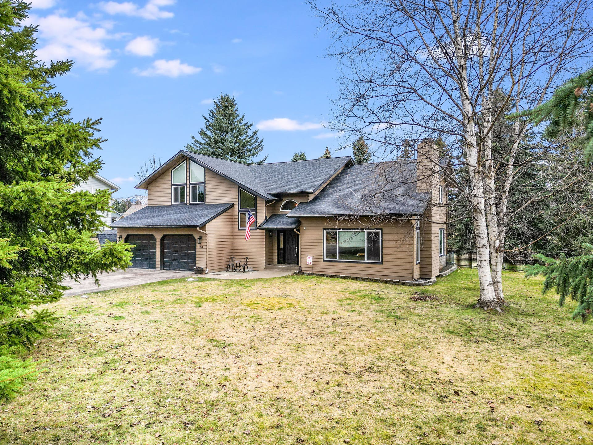 163 Crestview Drive, Bigfork, MT 59911 Welcoming front exterior featuring a low-maintenance lawn, mature birch trees, and a classic covered entryway
