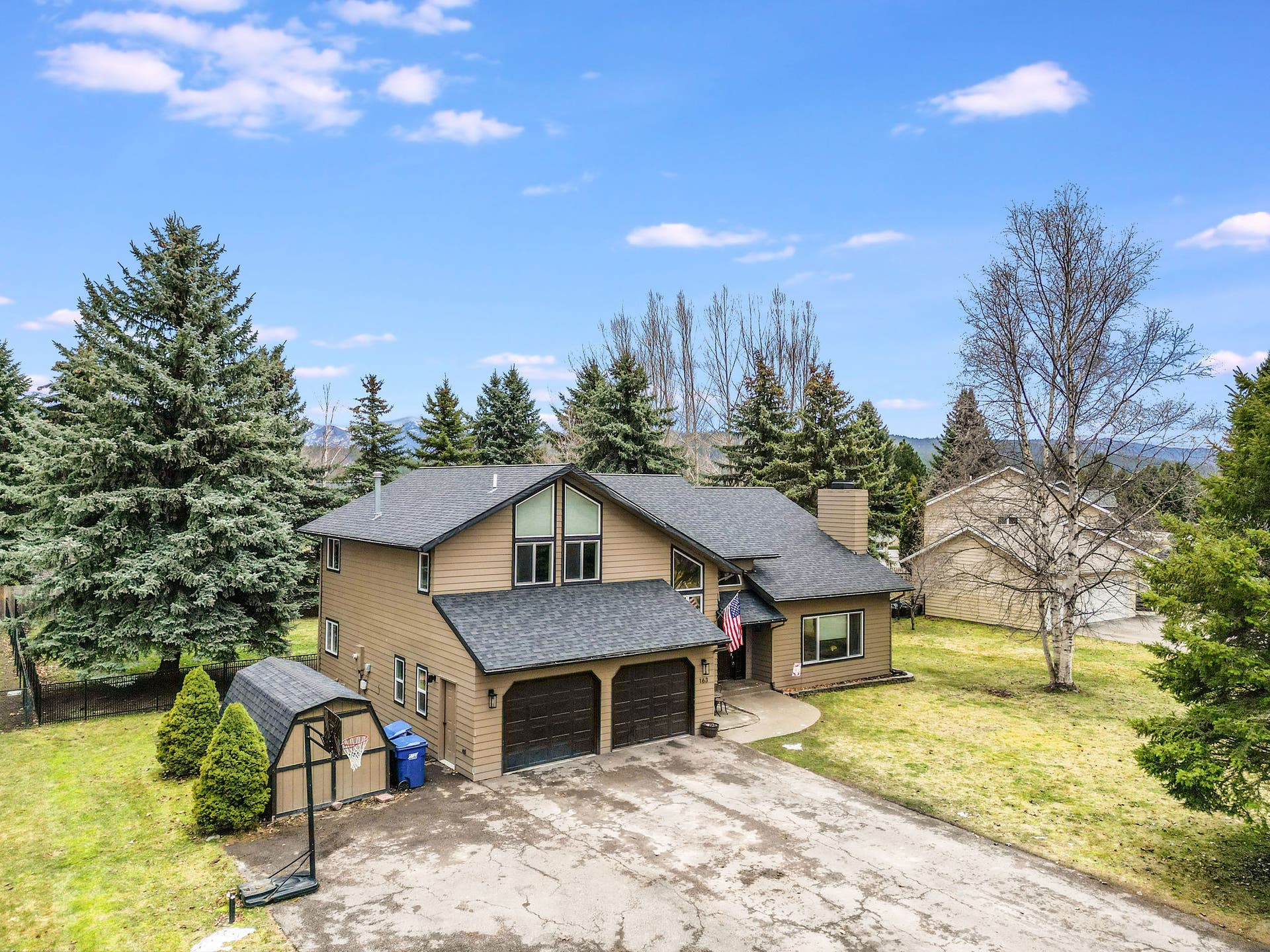 163 Crestview Drive, Bigfork, MT 59911 Welcoming front exterior featuring a low-maintenance lawn, mature birch trees, and a classic covered entryway
