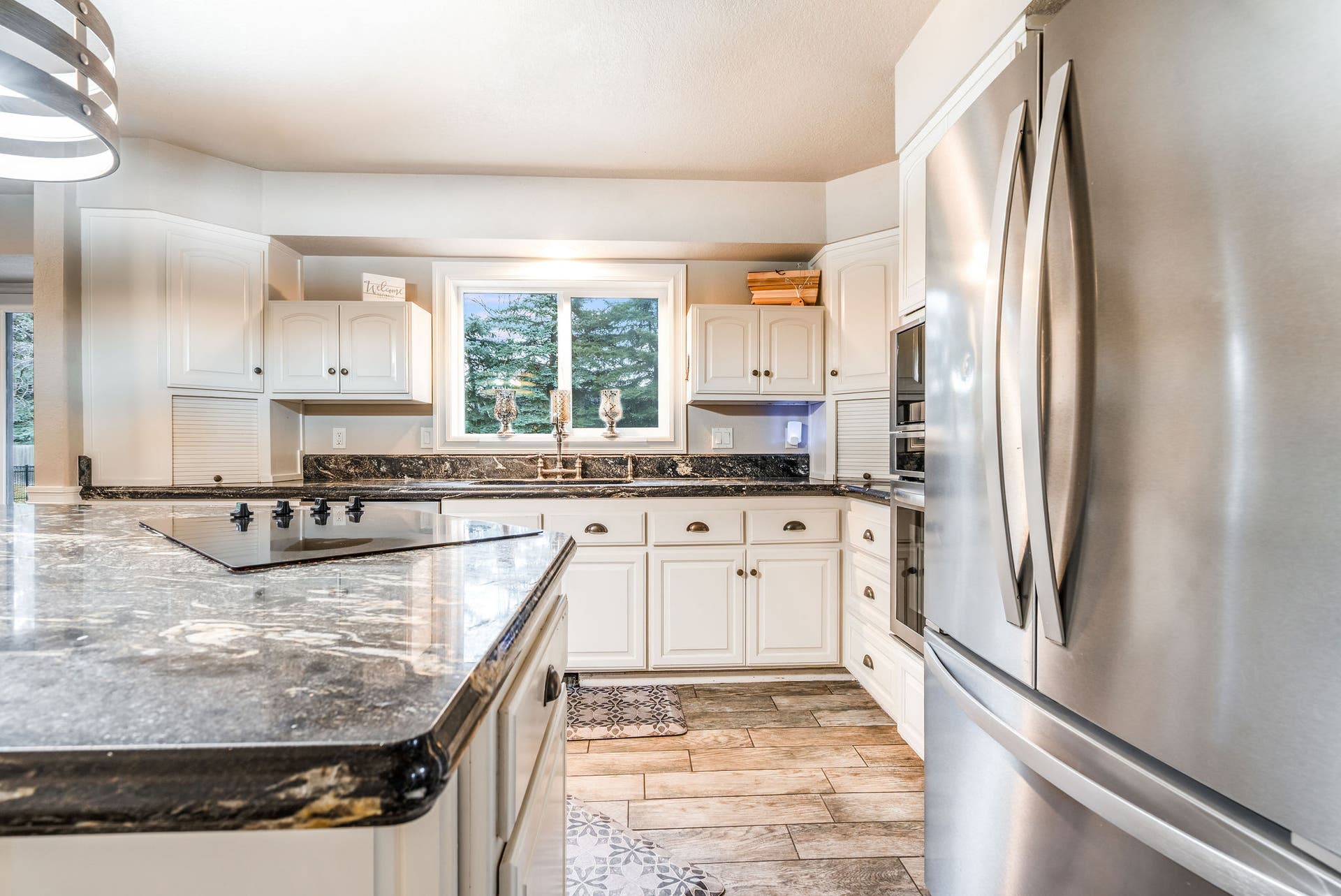 163 Crestview Drive, Bigfork, MT 59911 Gourmet kitchen featuring crisp white cabinetry, stainless steel appliances, and striking granite countertops