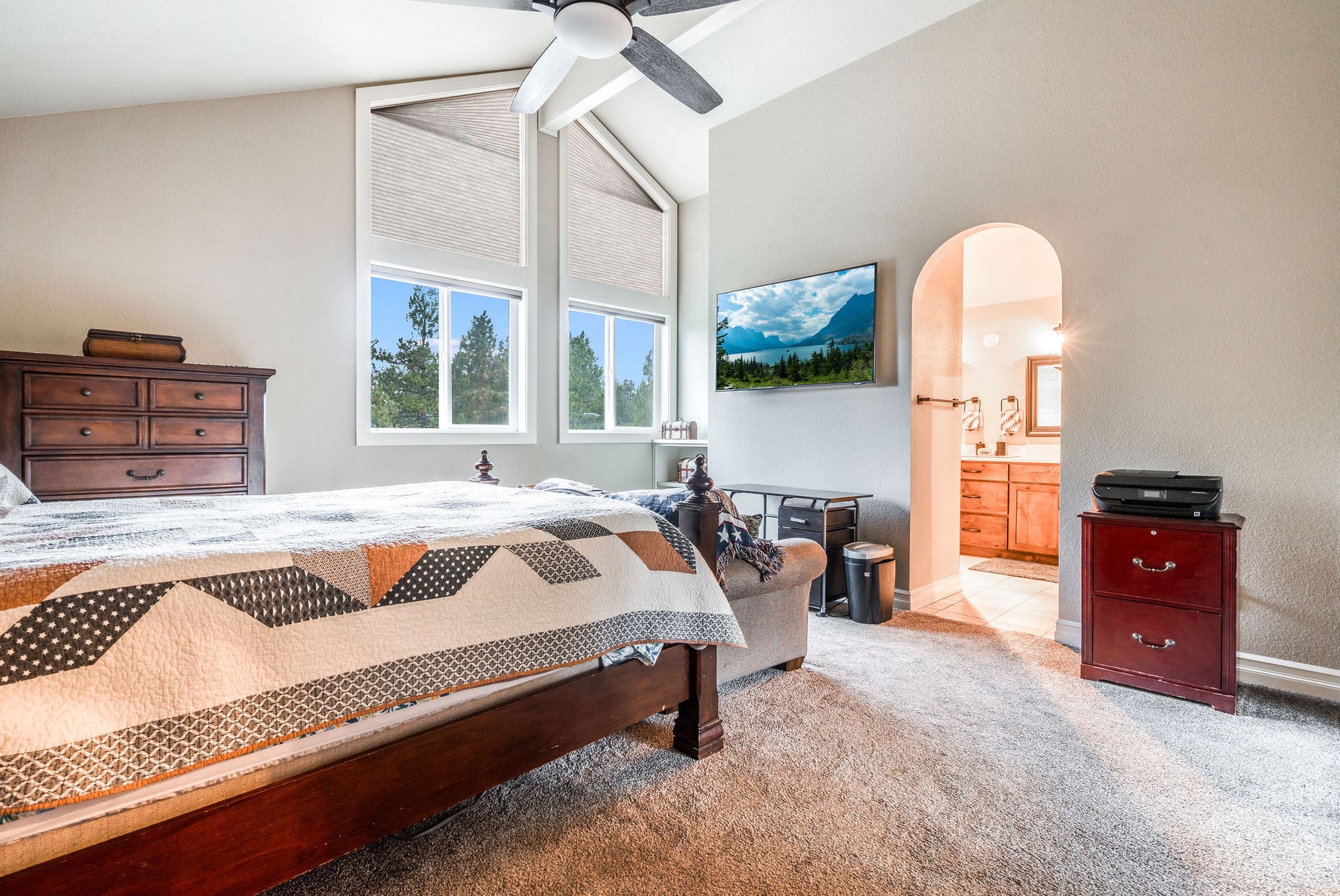 163 Crestview Drive, Bigfork, MT 59911 Primary bedroom retreat featuring vaulted ceilings, large windows, and a private ensuite bath