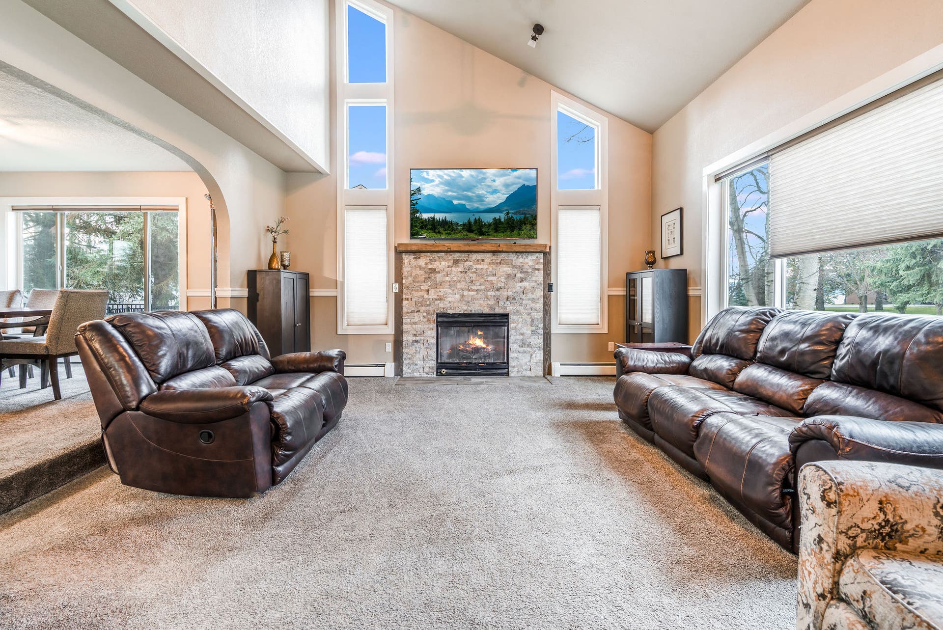 163 Crestview Drive, Bigfork, MT 59911 Spacious living room anchored by a floor-to-ceiling stone fireplace and vaulted ceilings