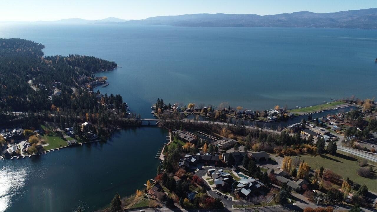 Expansive waterfront property with direct access to a large body of water, surrounded by mature trees and residential areas