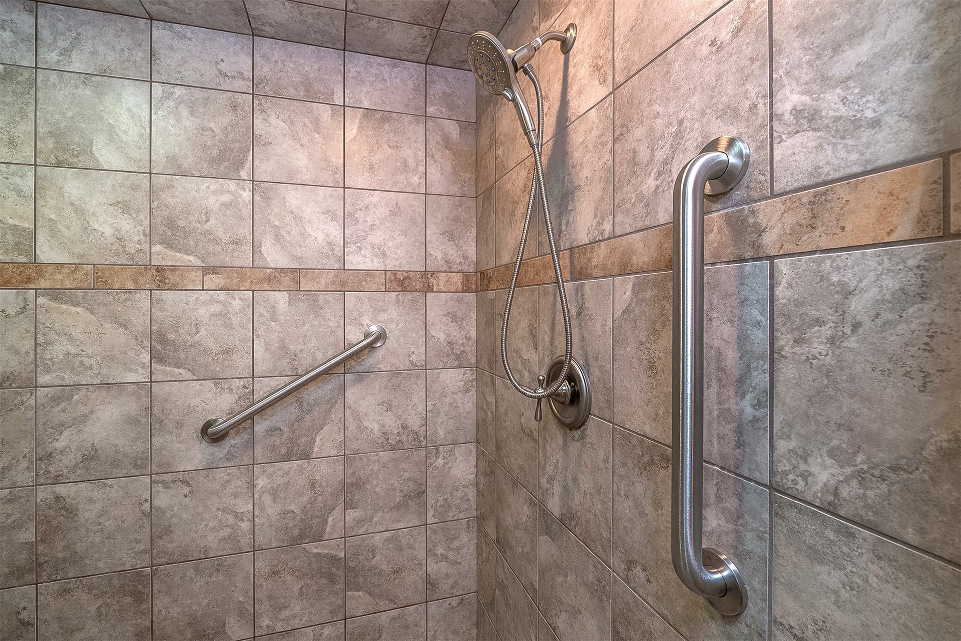 777 Mt Highway 83, Bigfork, MT 59911 Tiled shower enclosure featuring stone-look rectangular tiles and a decorative accent band