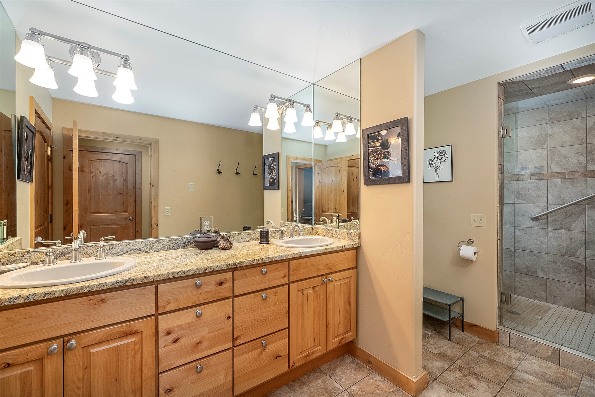 777 Mt Highway 83, Bigfork, MT 59911 Bathroom featuring a double vanity with two undermount sinks, a light-toned countertop, and light wood cabinetry