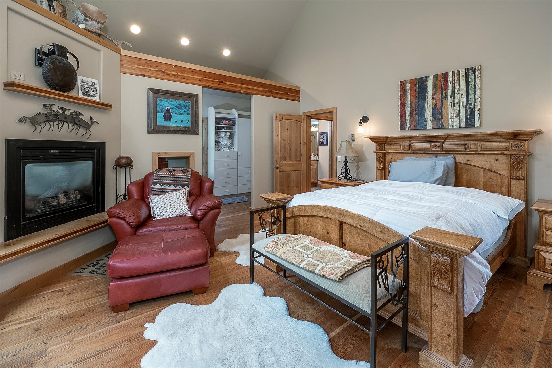 777 Mt Highway 83, Bigfork, MT 59911 Vaulted ceiling bedroom featuring wood-finish flooring and a built-in fireplace