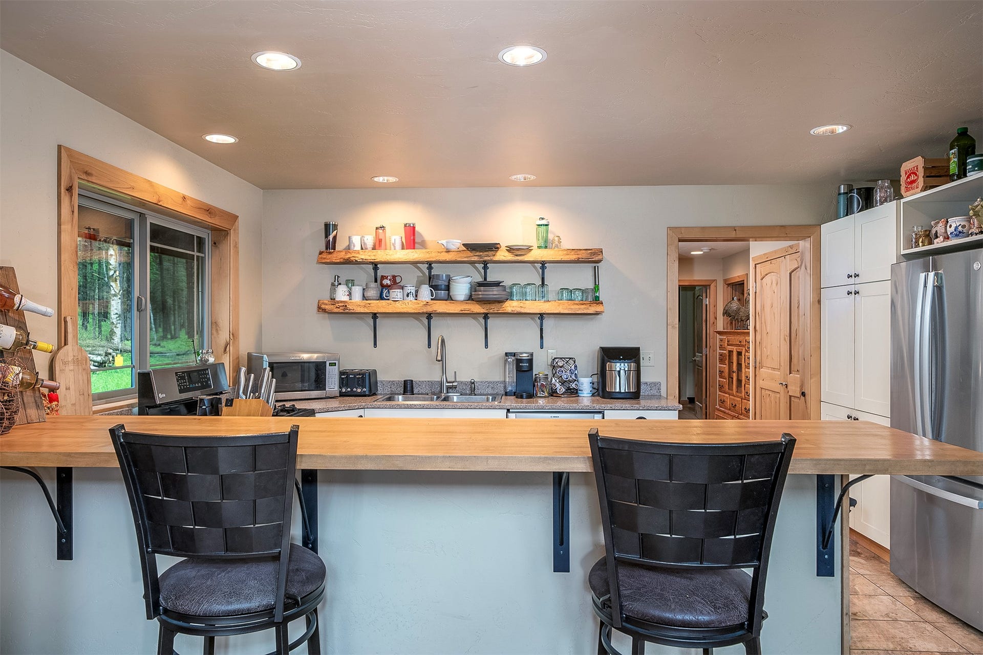 777 Mt Highway 83, Bigfork, MT 59911 Kitchen featuring wood-finish countertops, stainless steel appliances, open shelving, recessed lighting, and a window with wood trim