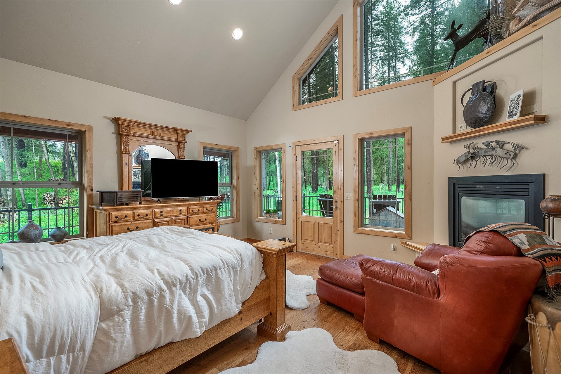 777 Mt Highway 83, Bigfork, MT 59911 Interior space featuring vaulted ceilings, a built-in fireplace, a wood-finish floor, and multiple windows with wood trim