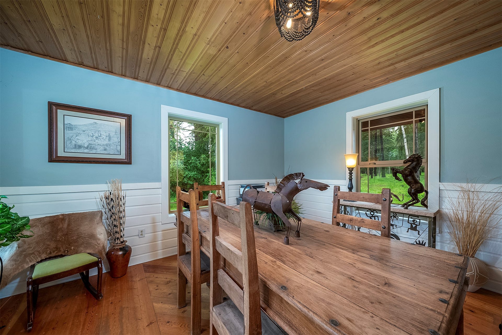 777 Mt Highway 83, Bigfork, MT 59911 Dining area featuring a wood-finish plank ceiling, light blue and white paneling, and wood-finish flooring