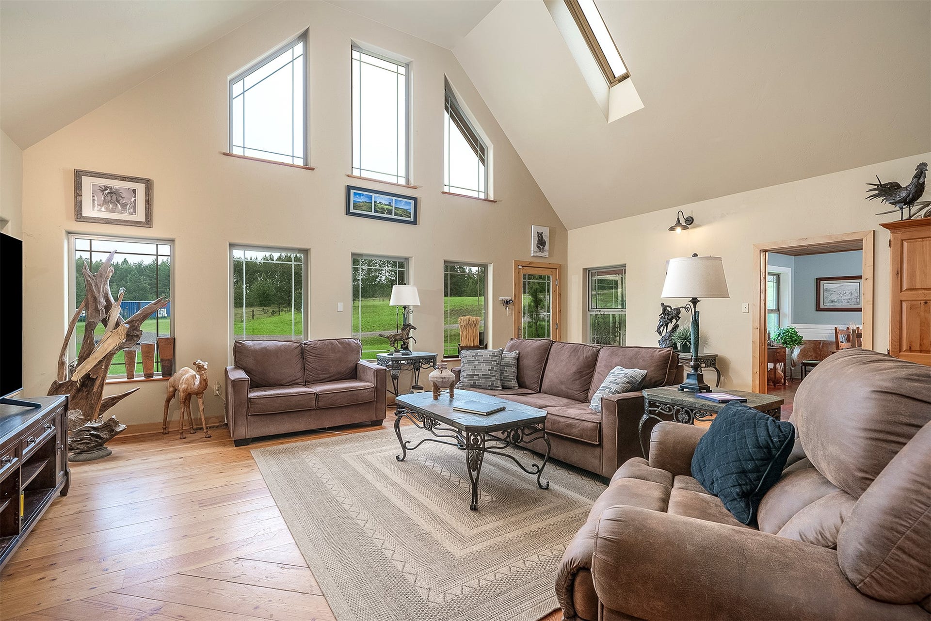 777 Mt Highway 83, Bigfork, MT 59911 Vaulted ceiling living space featuring skylights, light wood-finish flooring, and multiple windows