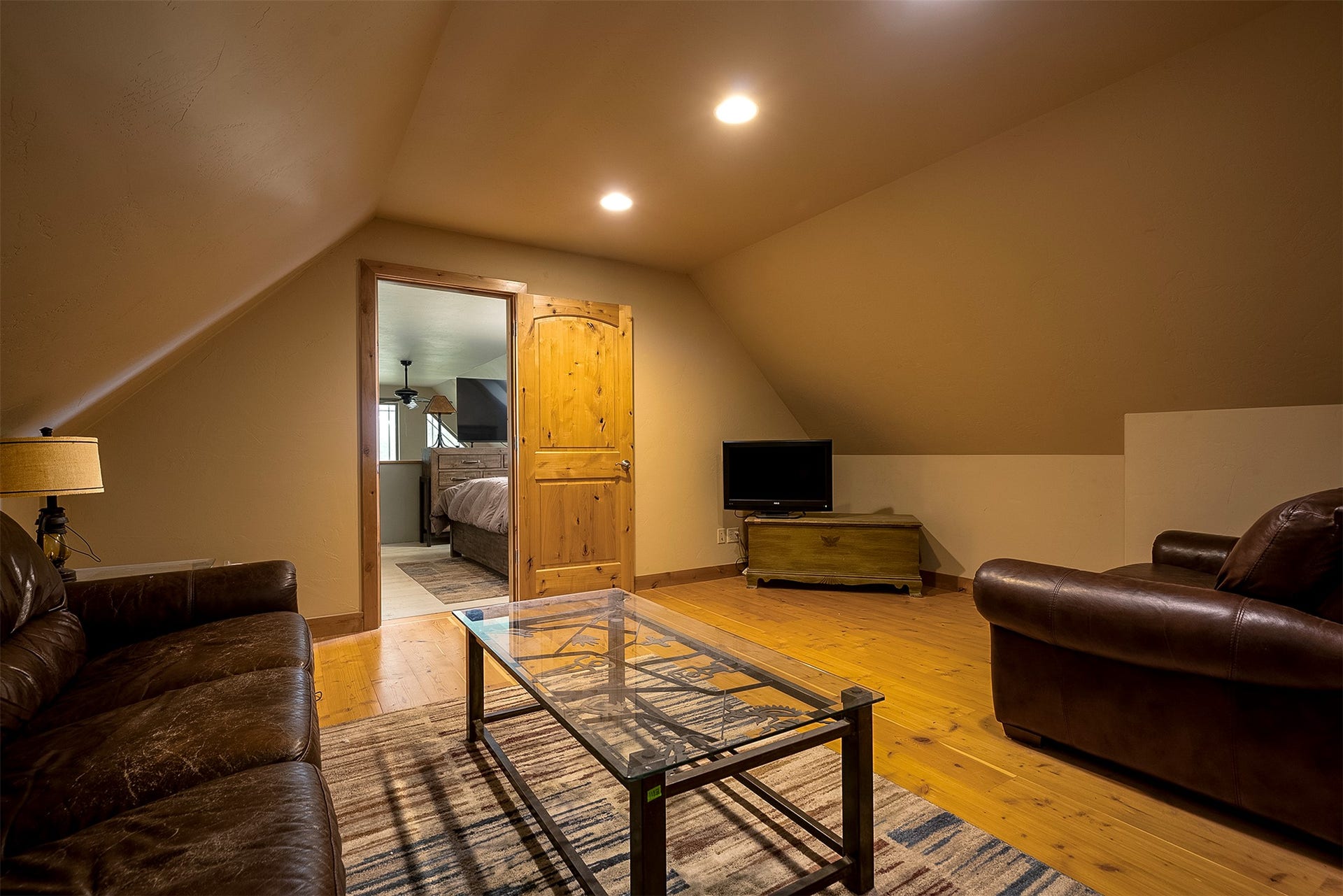 777 Mt Highway 83, Bigfork, MT 59911 Attic living space featuring sloped ceilings, recessed lighting, wood-finish flooring, and a knotty wood door frame