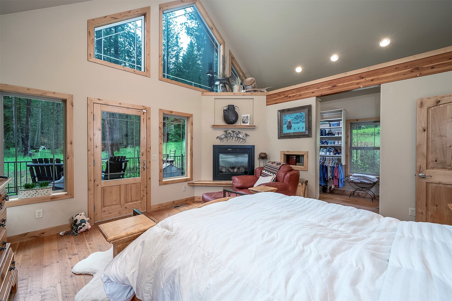 777 Mt Highway 83, Bigfork, MT 59911 Interior space featuring vaulted ceilings with exposed wood beams, extensive natural wood-finish trim, a corner fireplace, recessed lighting, and wood-finish flooring