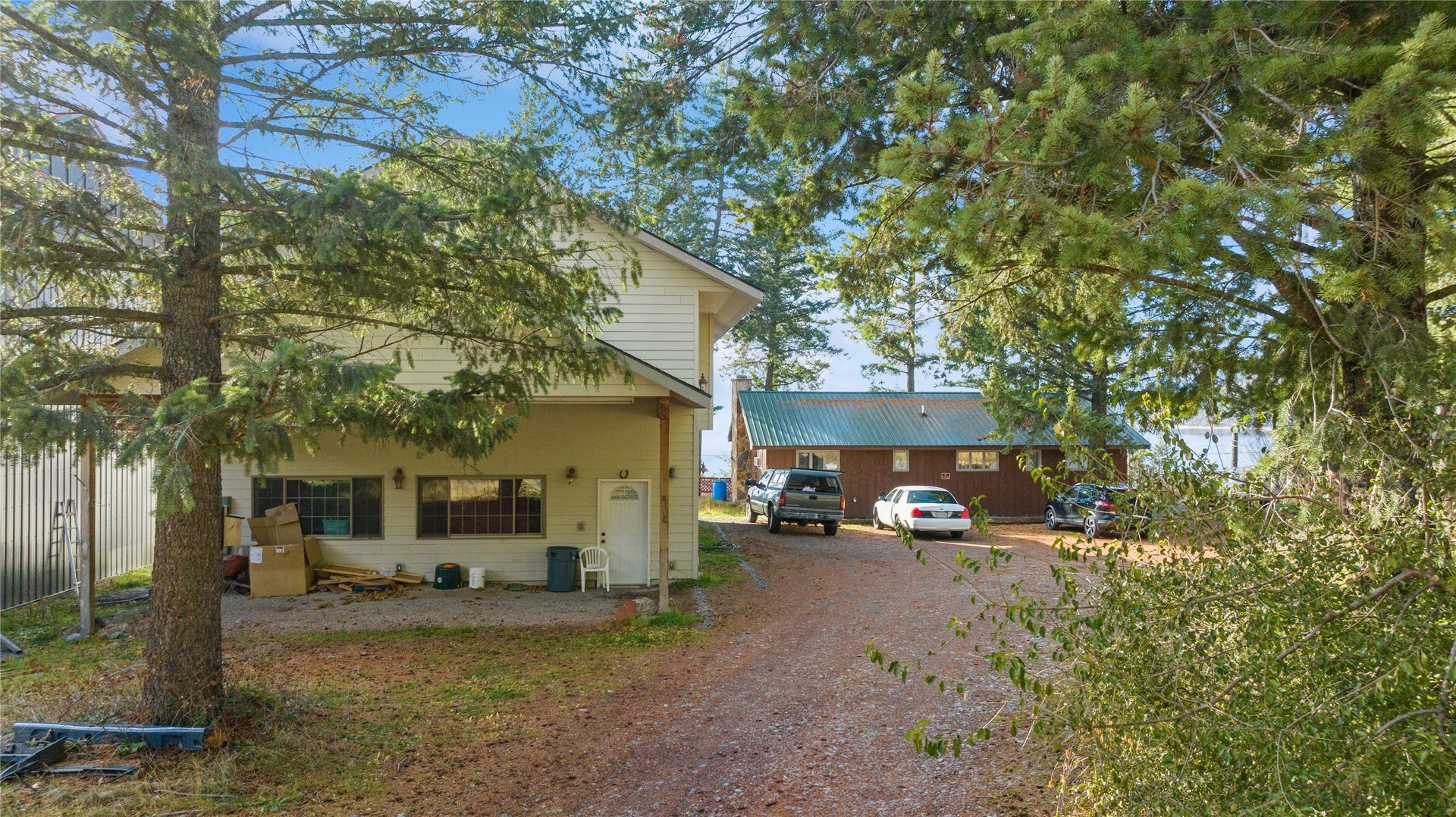 15236 Mt Highway 35, Bigfork, MT 59911 Looking E to W at guest quarters and 3 car attached garage. Main original residence (1975) in the background to the right of guest quarters and garage.