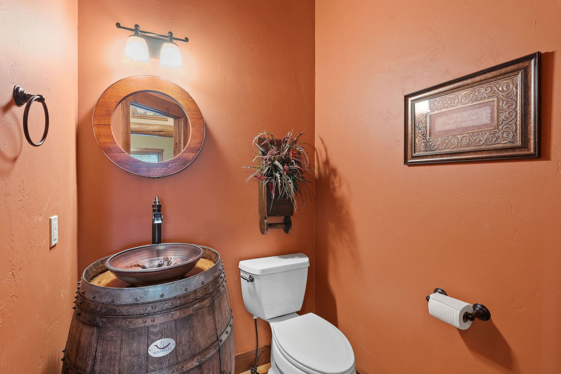 129 Bjork Drive, Bigfork, MT 59911 Guest Powder room by foyer, wine barrel cabinet with custom pottery sink & wine barrel mirror