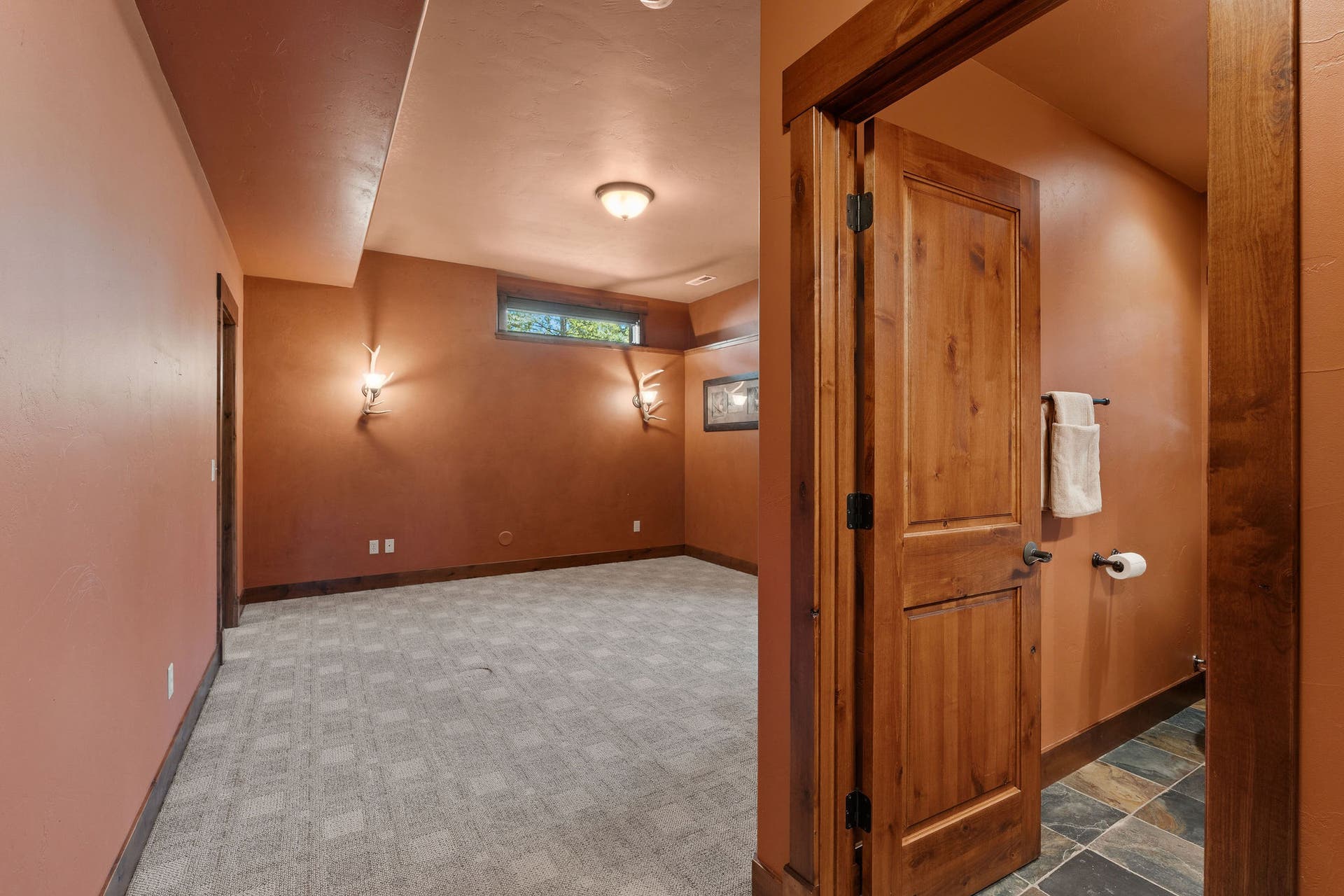 129 Bjork Drive, Bigfork, MT 59911 Lower level guest bedroom #1: ensuite full bath, high ceilings, elk antler light fixtures