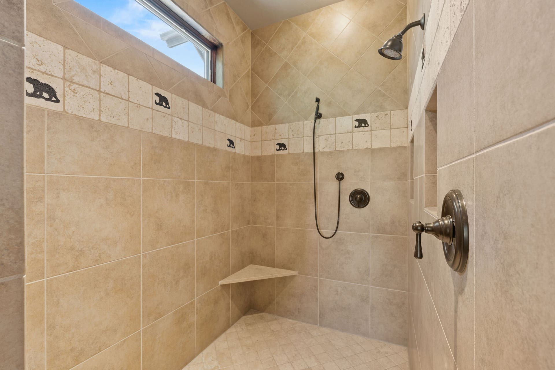 129 Bjork Drive, Bigfork, MT 59911 Large walk-in travertine tile shower with bear accents & window