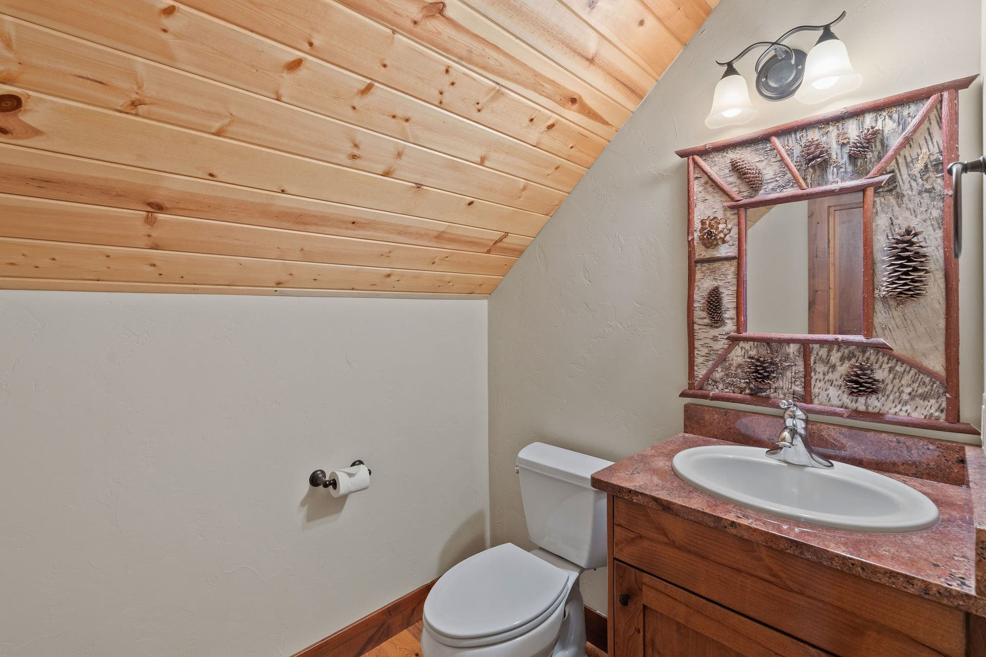 129 Bjork Drive, Bigfork, MT 59911 Guest 1/2 bath by bunk room, granite countertop, knotty alder cabinets, hardwood flooring