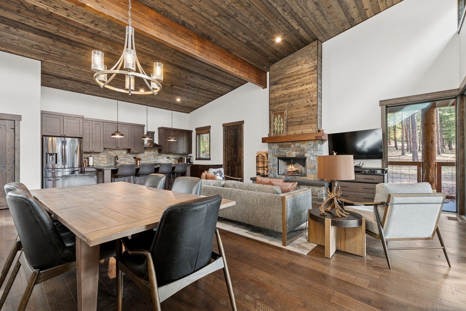 30 Boulder Lane, Eureka, MT 59917 Dining area featuring high vaulted ceiling, wooden ceiling, a notable chandelier, dark wood-type flooring, and beam ceiling