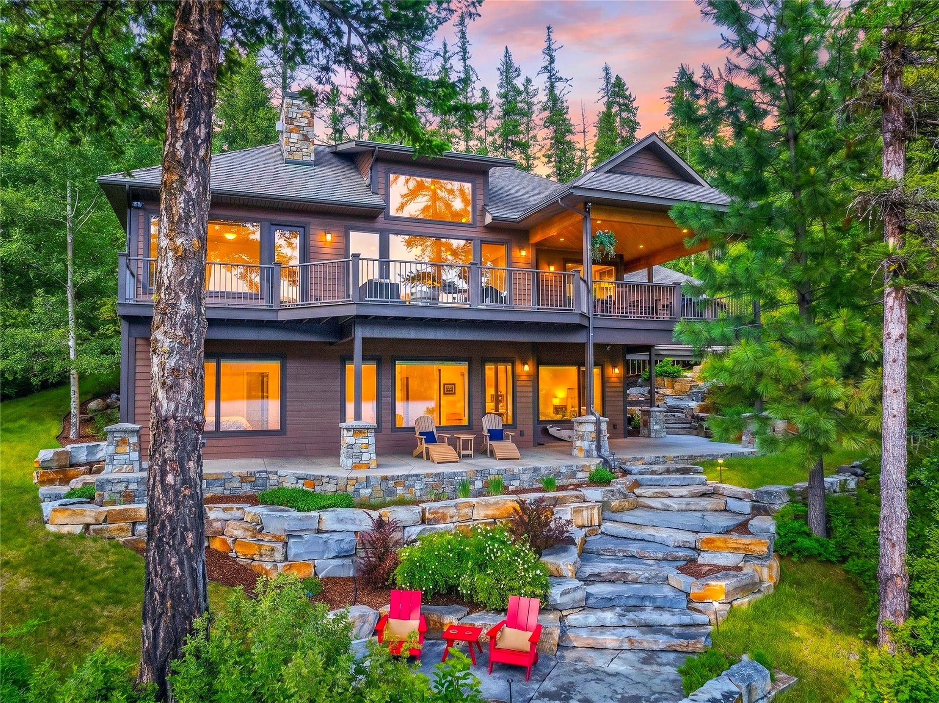 28575 Star Lane, Bigfork, MT 59911 Multi-level residence featuring a brown-toned exterior, multiple balconies with dark railings, and prominent window expanses