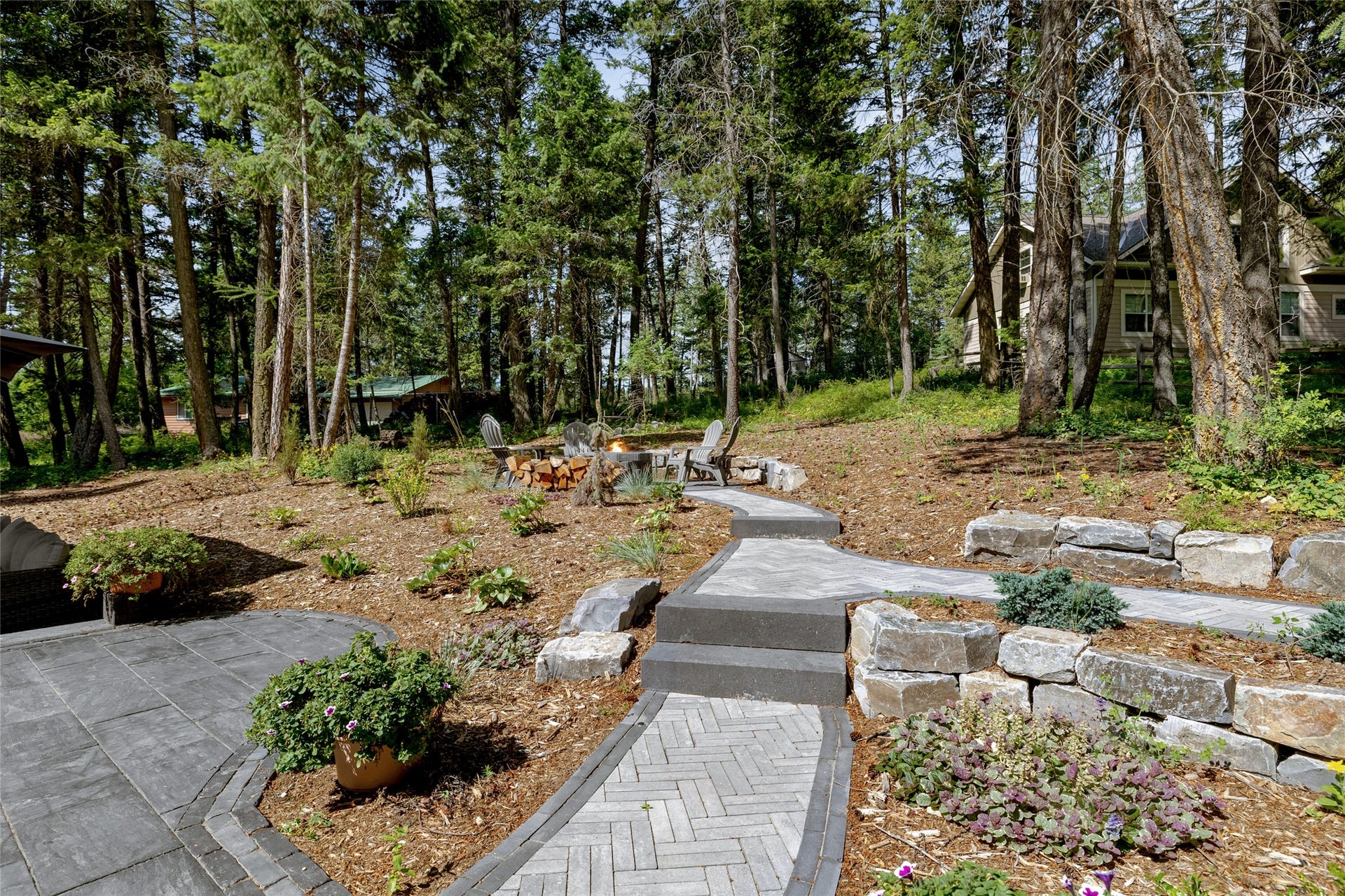 112 Mallard Loop, Whitefish, MT 59937 Upper level firepit with cooking equipment! Gorgeous .69 acre treed lot!