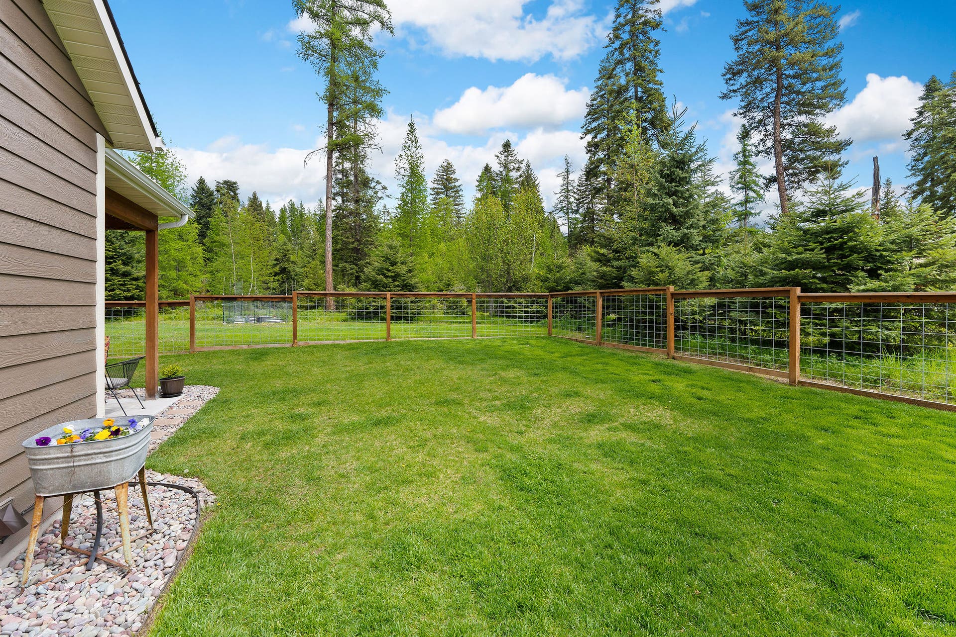 13404 Crescent Moon Drive, Bigfork, MT 59911 Generous, secure side yard completely enclosed by smooth wire and wood fencing
